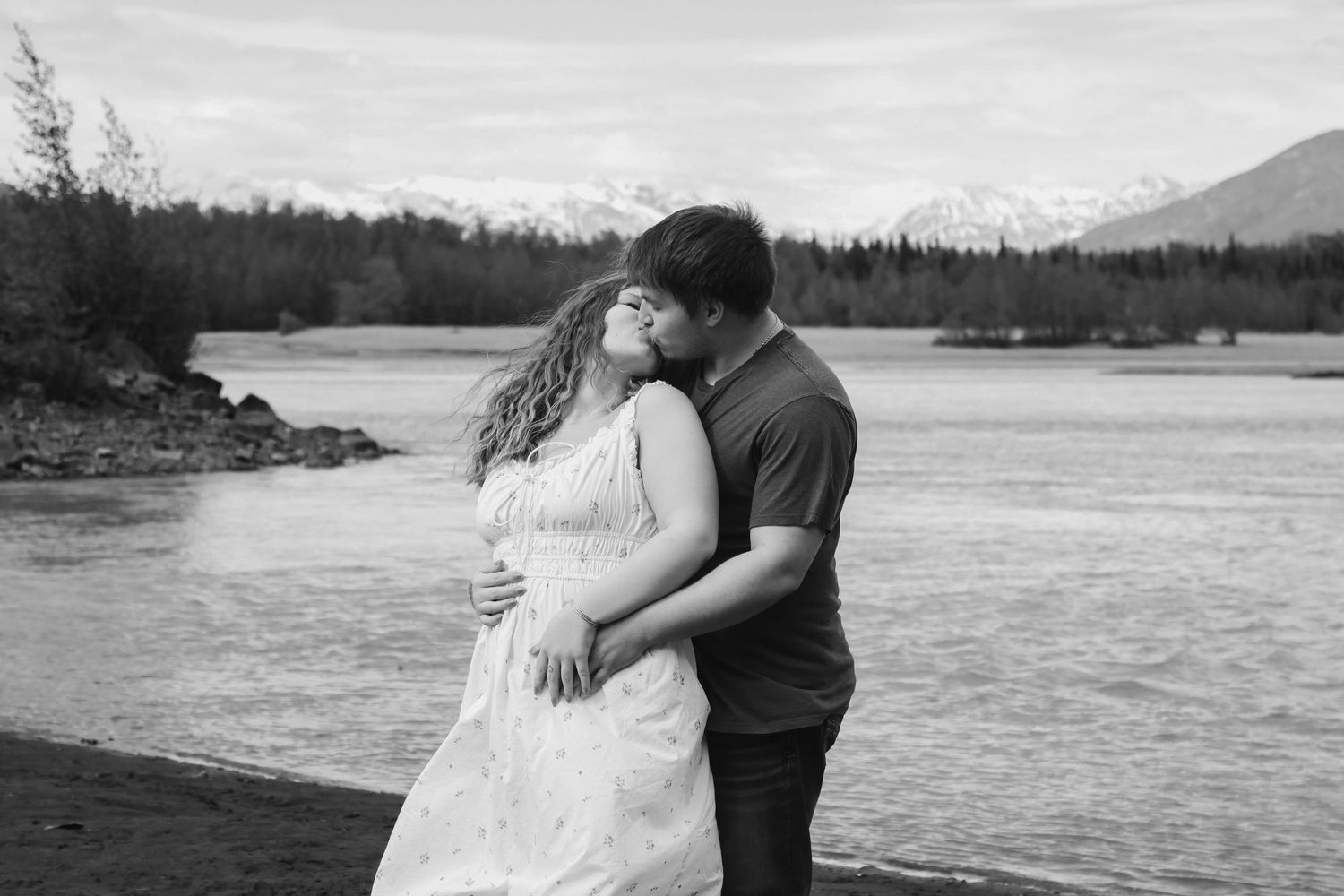 A collection of black and white romantic waterfront photos showing intimate moments between a couple at the beach.