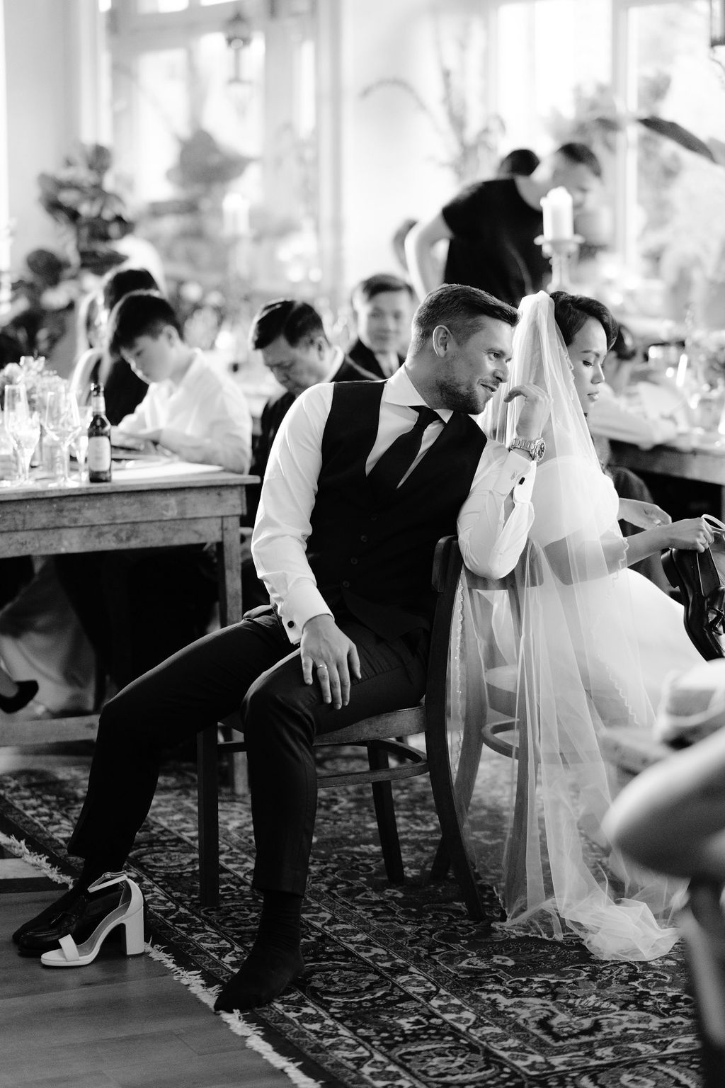 A series of black and white wedding reception photos showing guests on a dance floor with floral carpet.
