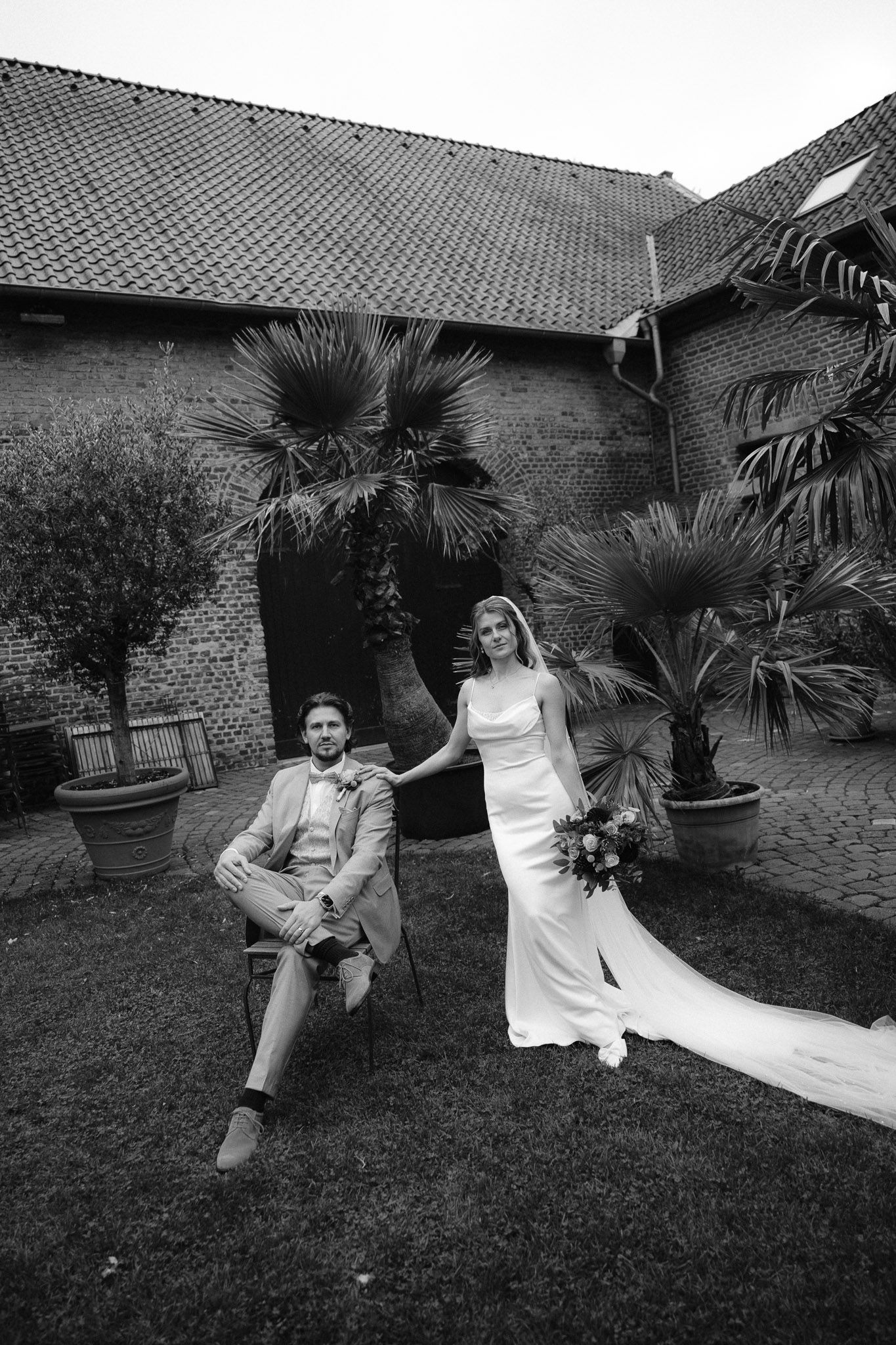 A black and white wedding photo sequence shows a couple posing playfully on a lawn with palm trees in the background.