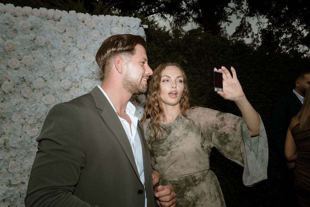 Guests share a joyful moment blowing smoke during a wedding celebration.