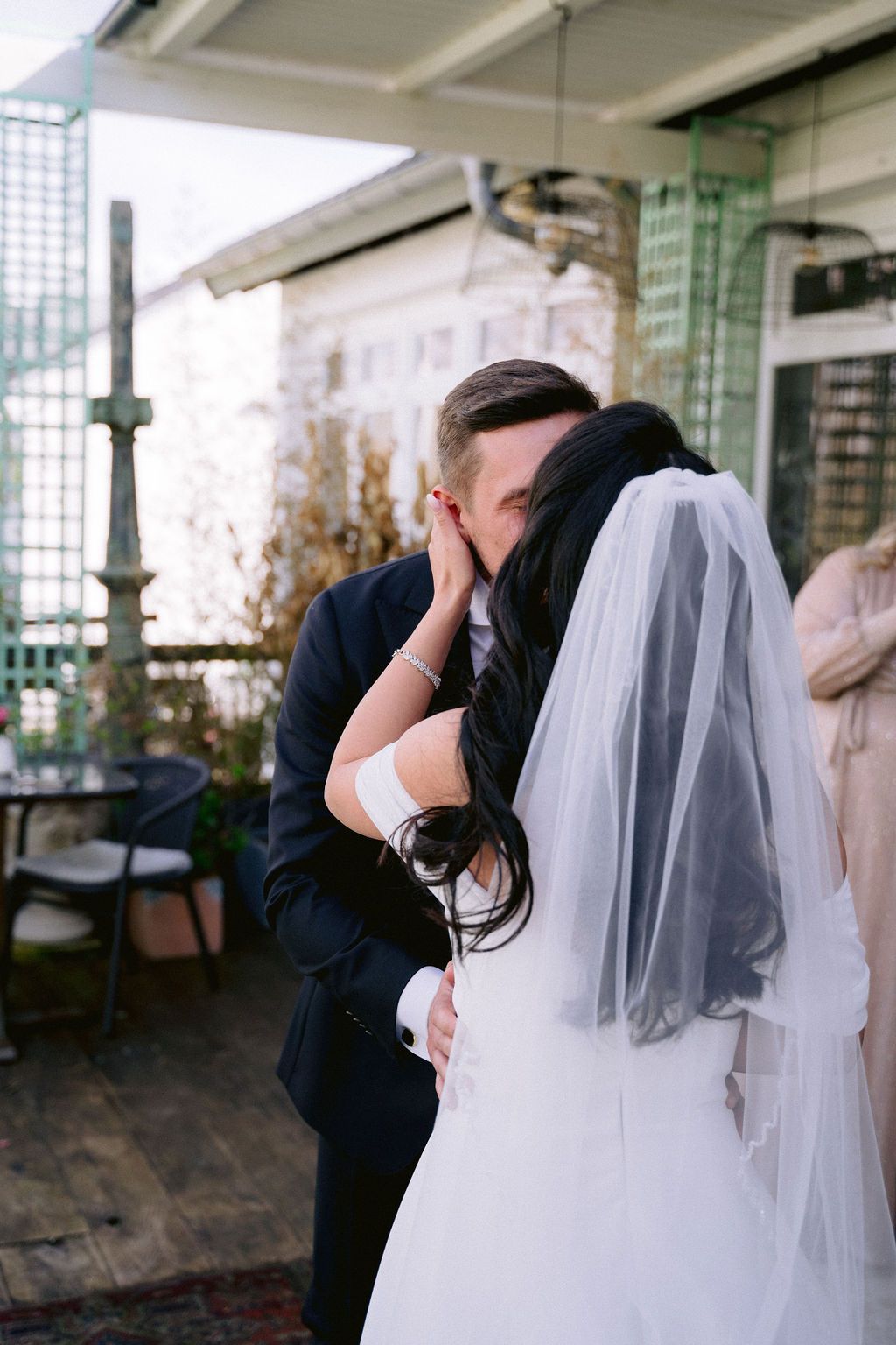 A series of romantic wedding photos showing a couple embracing and kissing under a covered porch area.