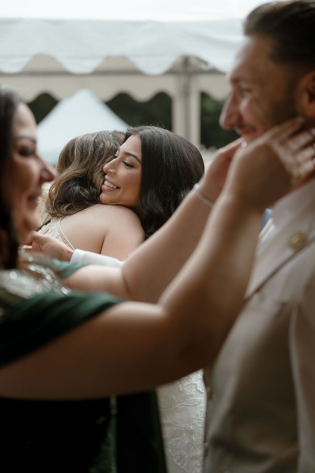 An emotional moment is captured as wedding guests embrace and share joyful hugs during a celebration.