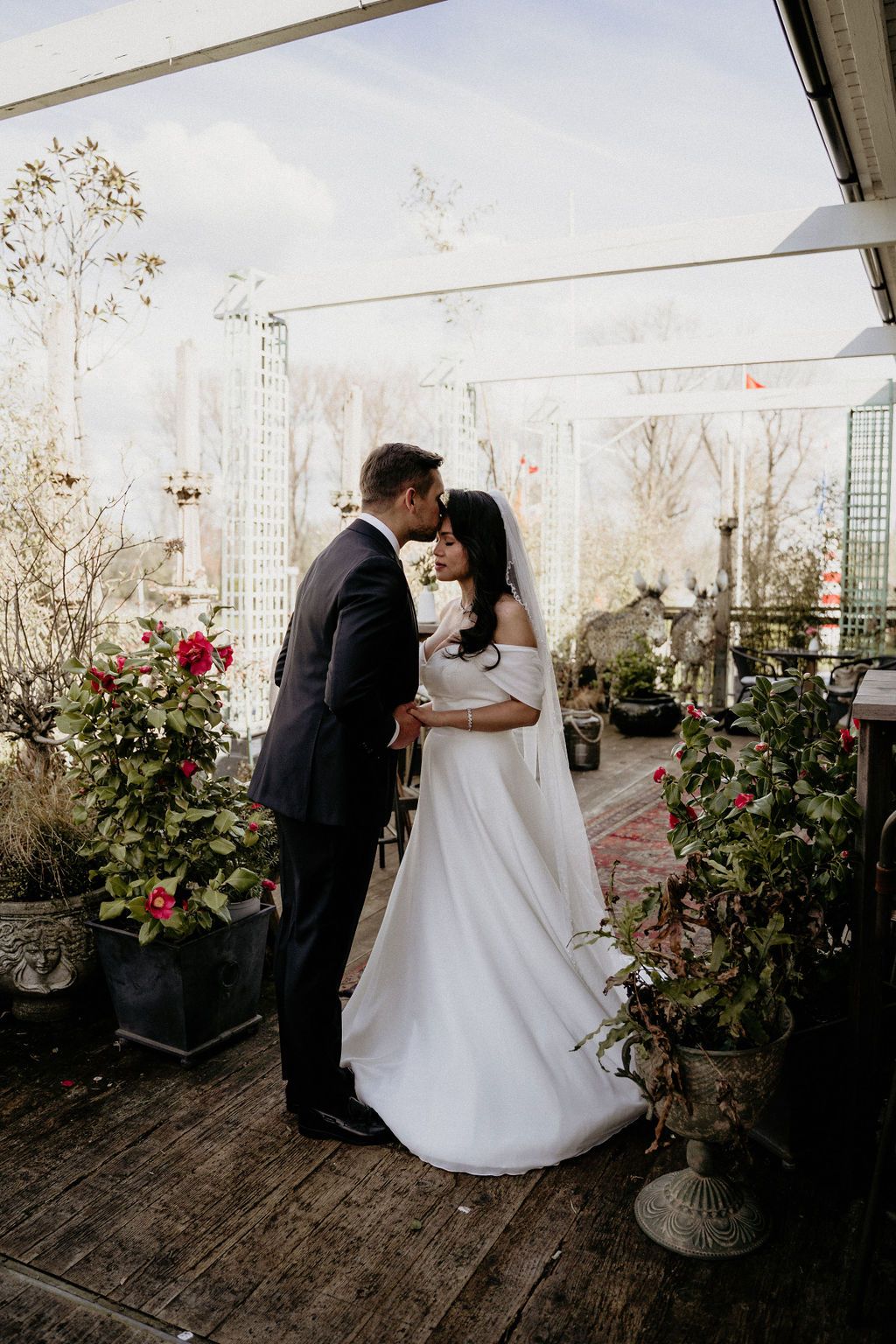 A romantic first dance sequence of newlyweds in black and white captured at an elegant indoor conservatory venue.