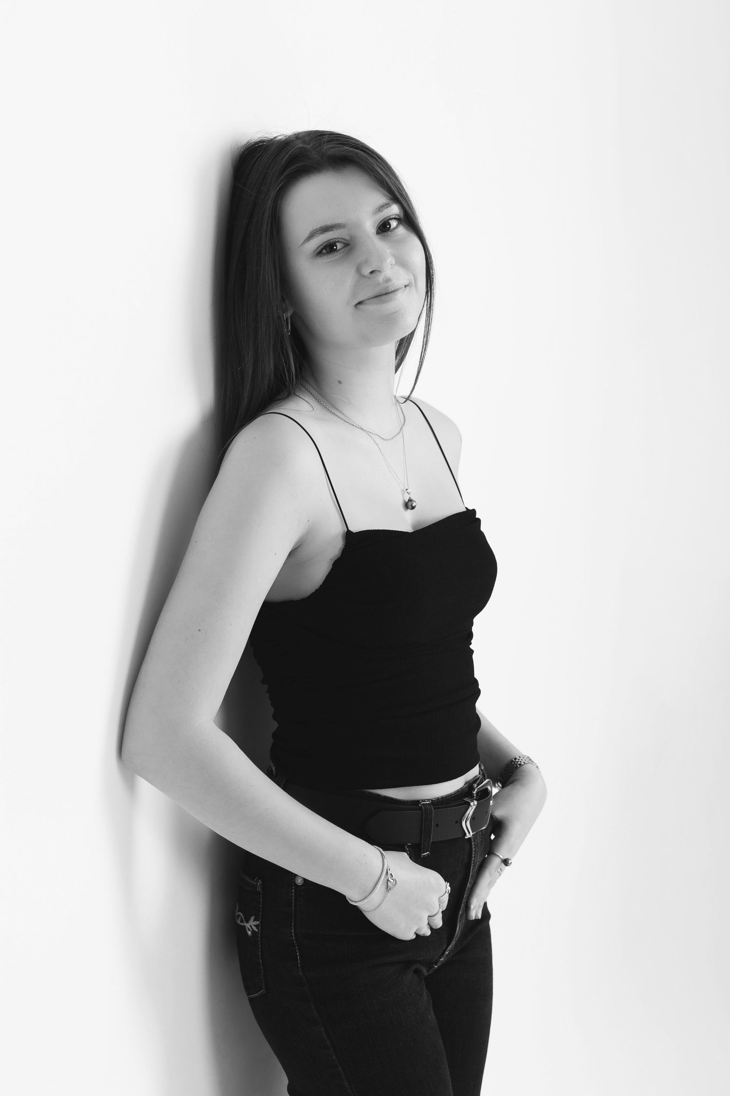 A series of four black and white portraits showing someone in a black top against a white background.