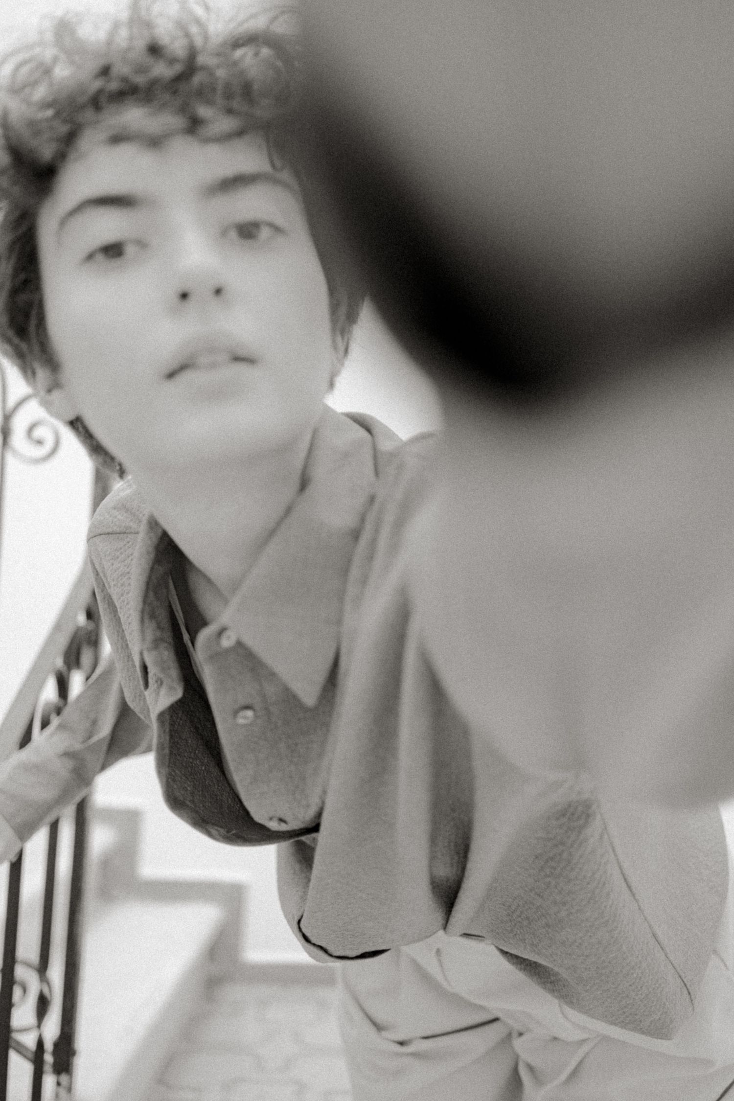 A black and white collage of artistic portrait shots showing contemplative poses against a light background.