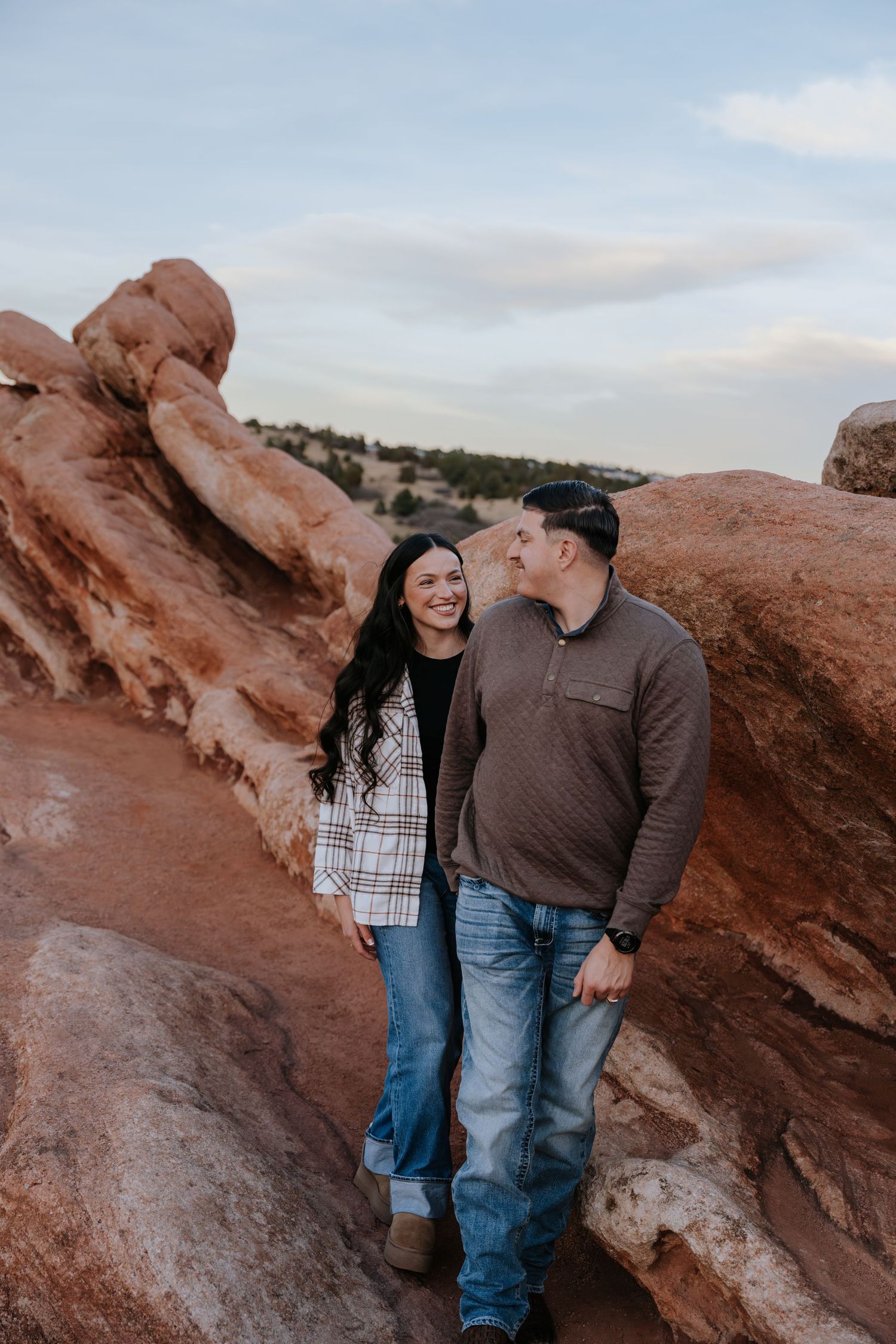 Happy couple laughing together between red sandstone rock formations at Garden of the Gods Colorado.