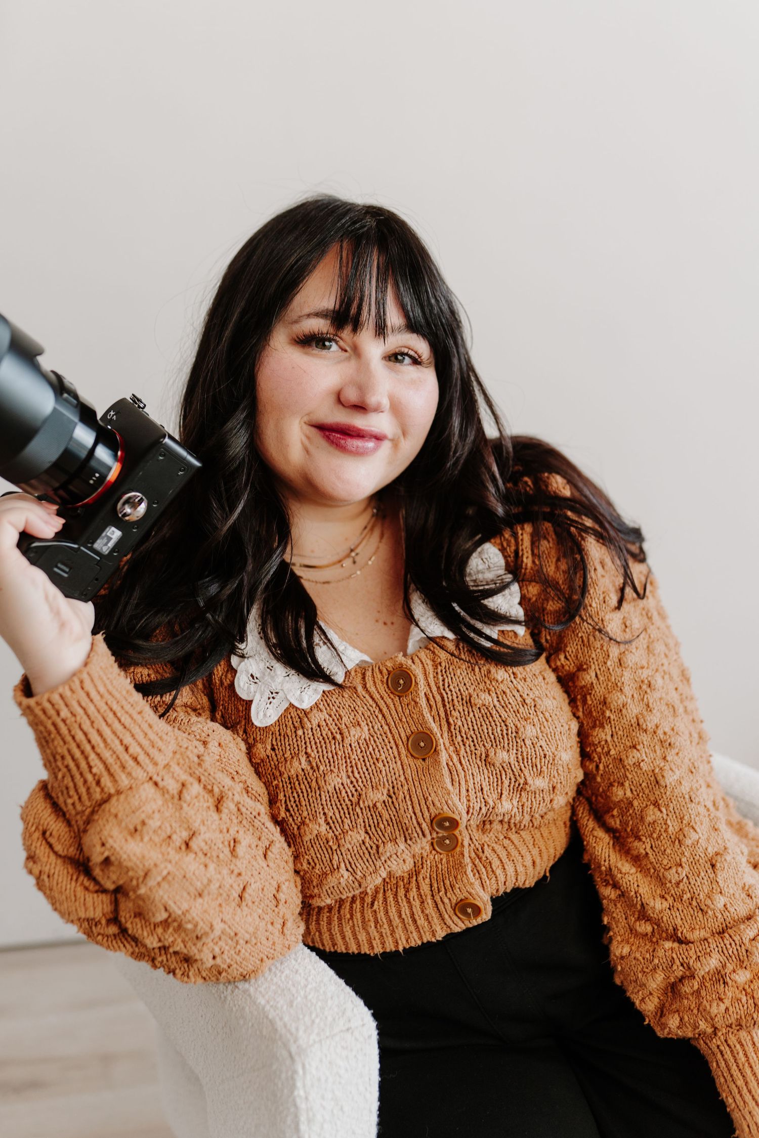 A person in a brown textured sweater poses with a camera against a light background in a series of lifestyle photos.
