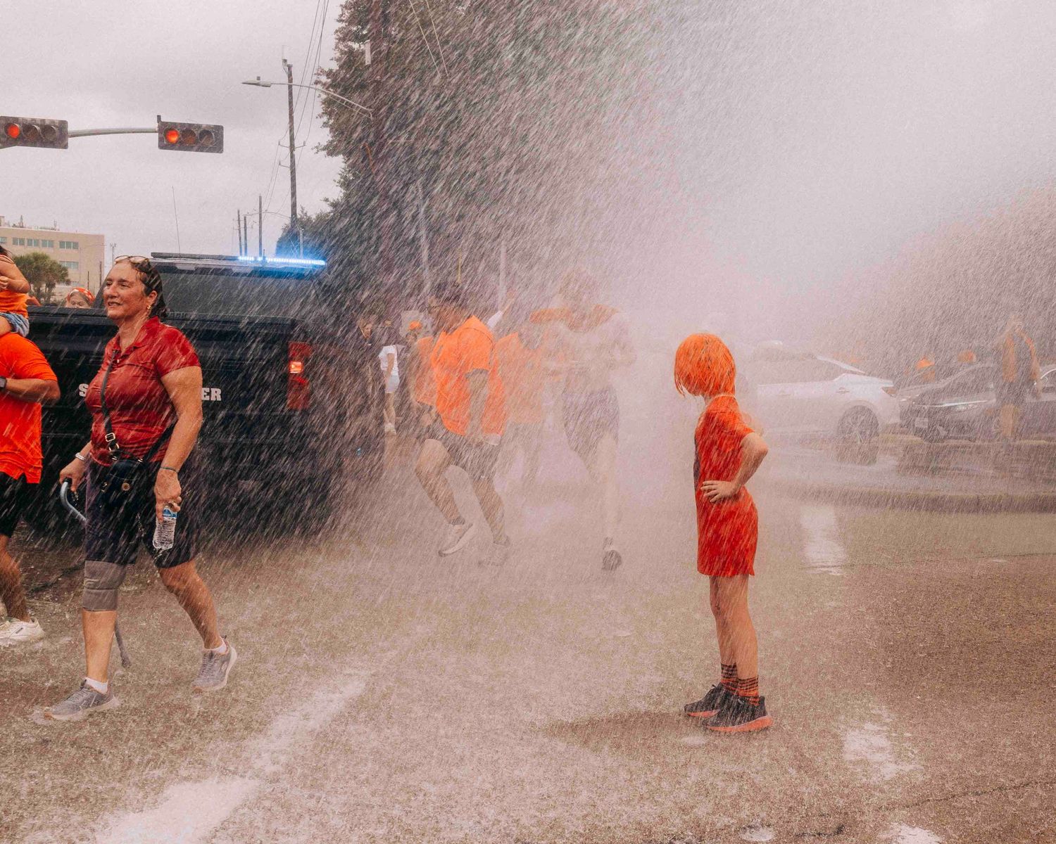 FIFA World Cup 2026 Houston | Kid cools off in water from a Houston Fire Dept hose during the Orange Bus fan walk | Photos by Robert Paul