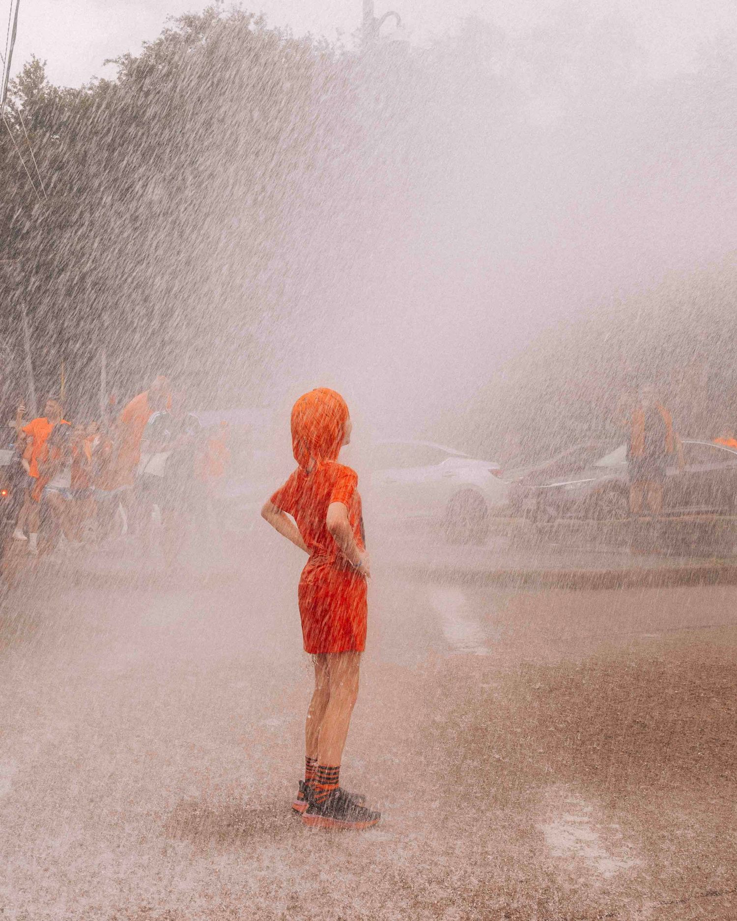 FIFA World Cup 2026 Houston | Kid cools off in water from a Houston Fire Dept hose during the Orange Bus fan walk | Photos by Robert Paul