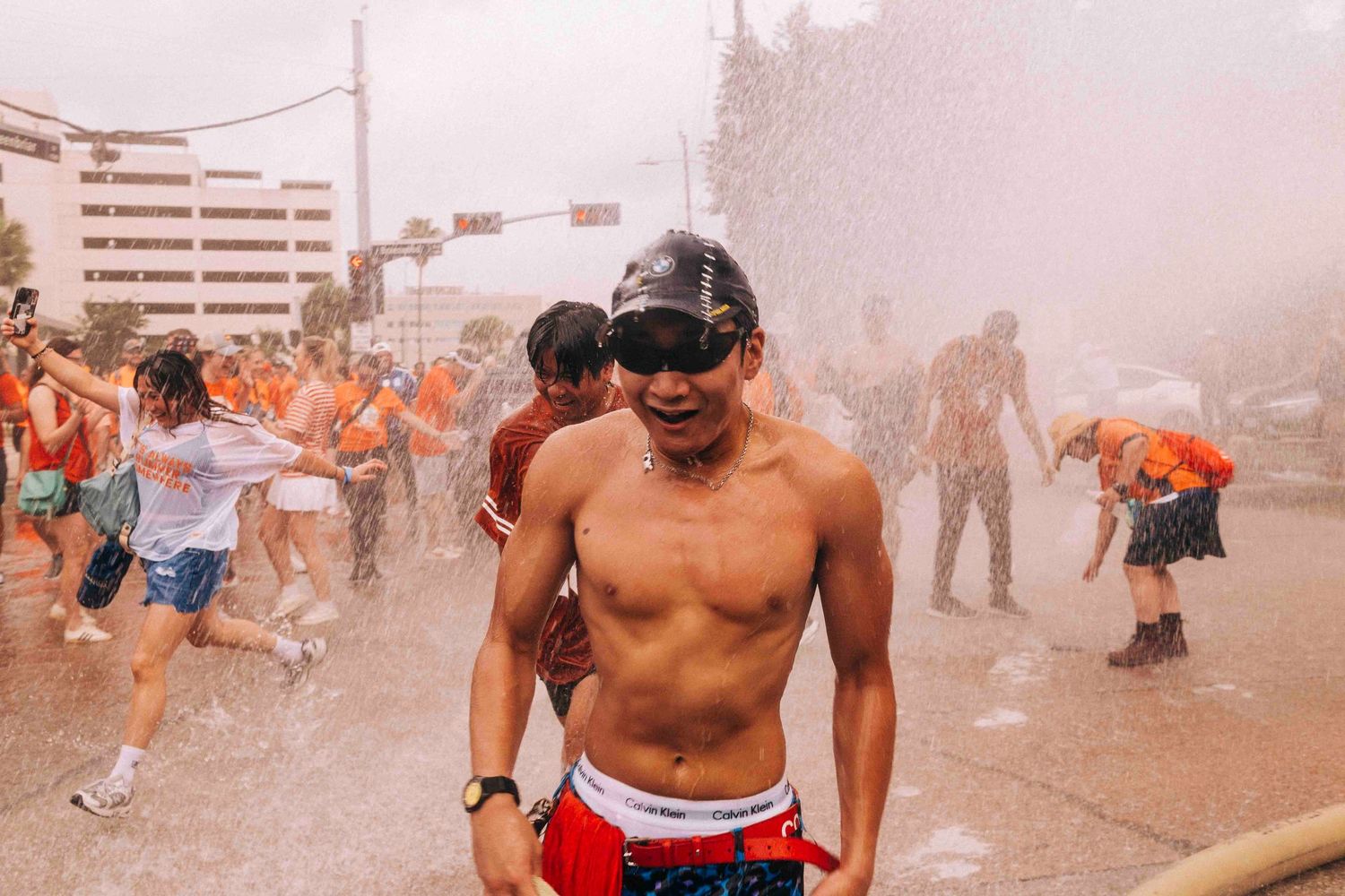 FIFA World Cup 2026 Houston | Man cools off under the firehose from HPD during Orange Bus fan walk | Photos by Robert Paul