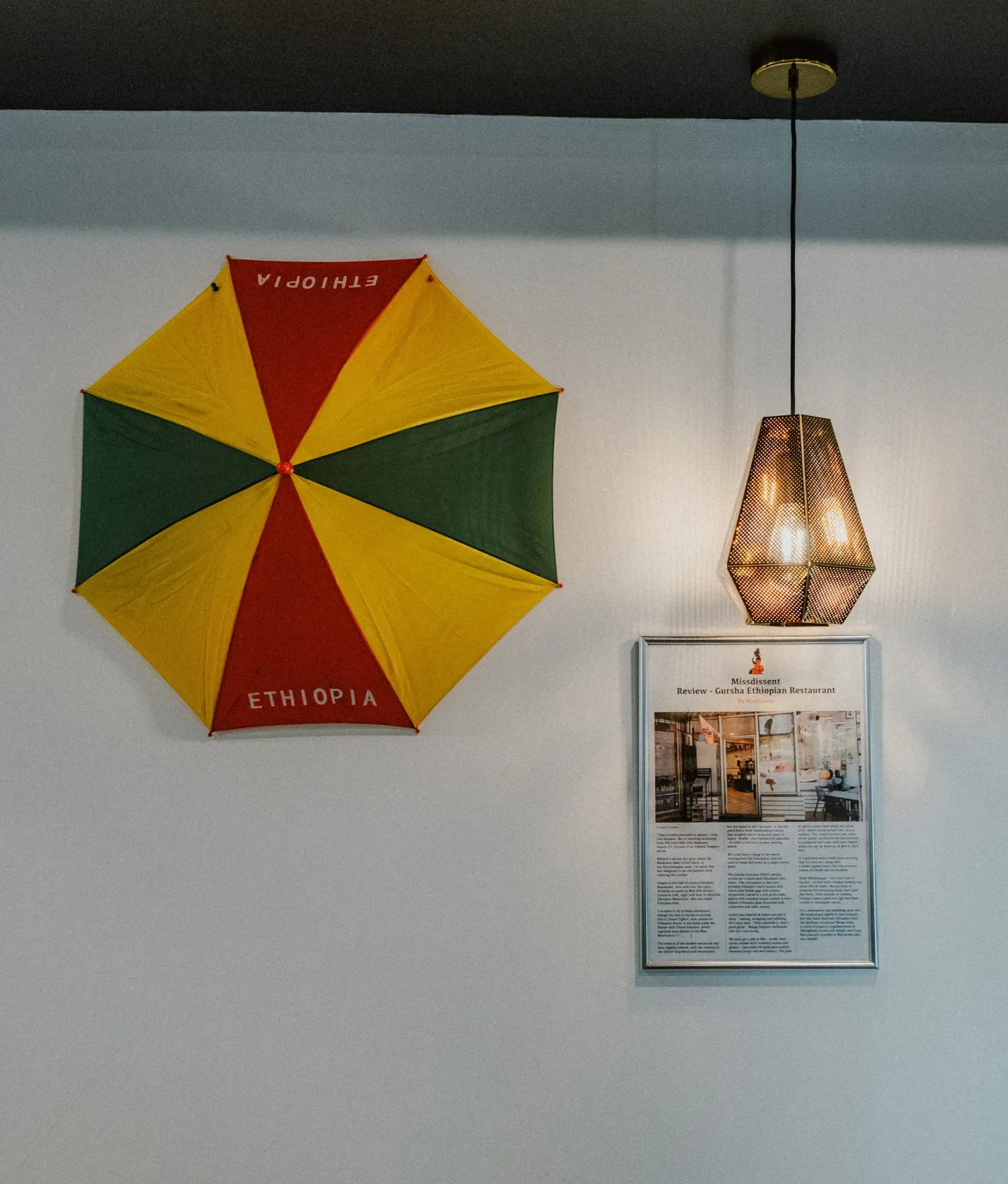 Ethiopian flag-colored umbrella and pendant light decorating the wall of an Ethiopian restaurant.