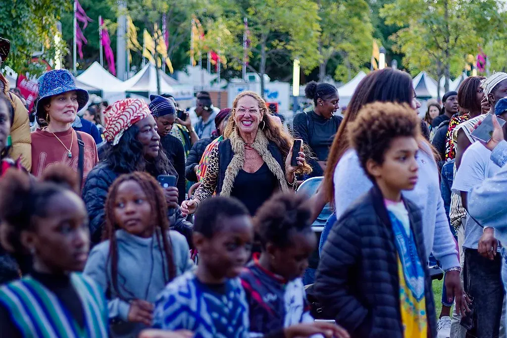 Joyful multicultural crowd celebrating together at a lively outdoor African cultural festival event.