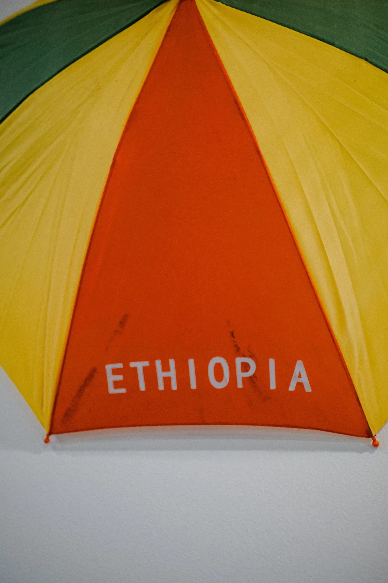 Colorful Ethiopian flag umbrella in green, yellow, and red with Ethiopia text.