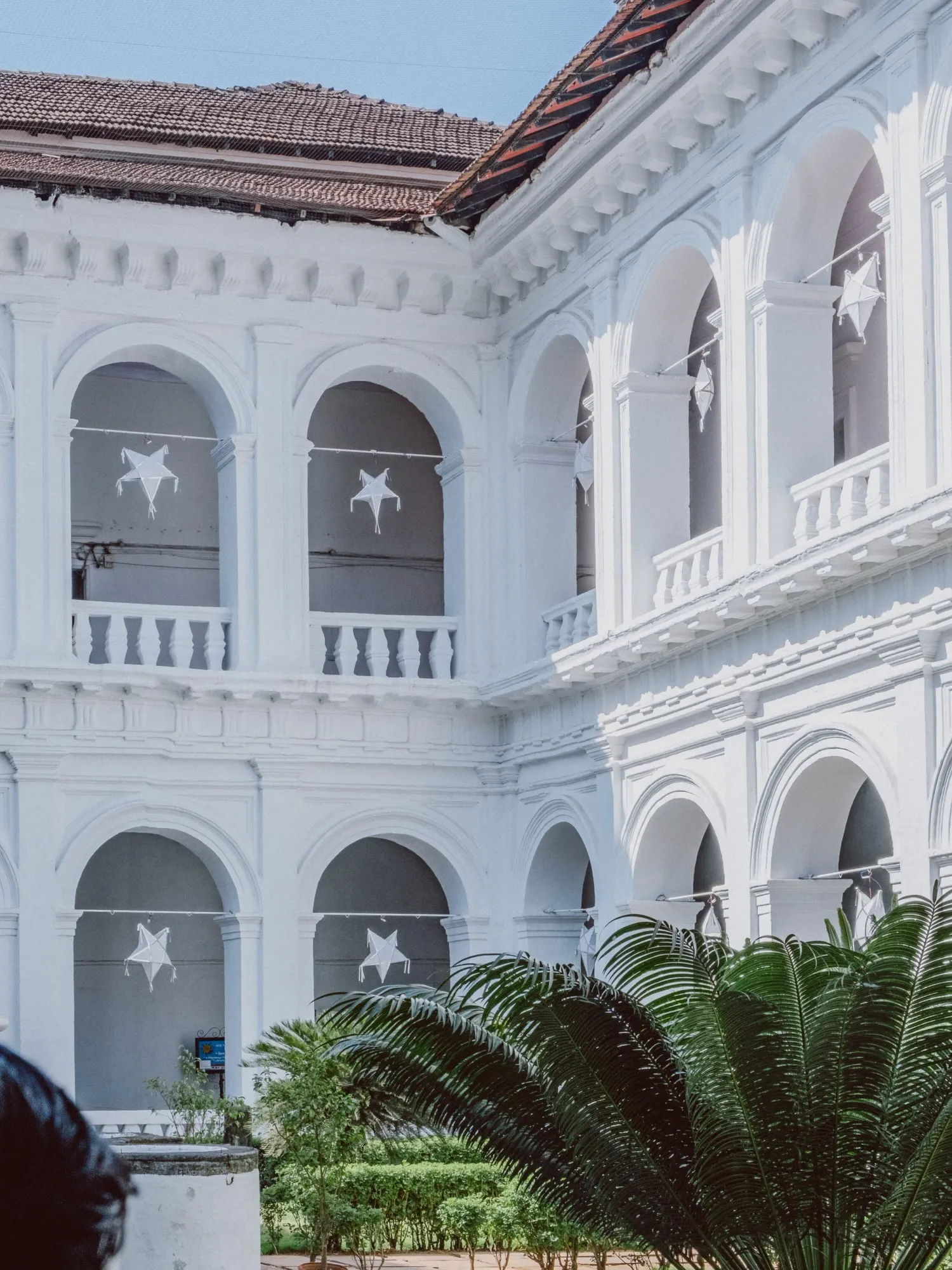 White colonial Portuguese architecture building with arched balconies and star decorations in Goa.