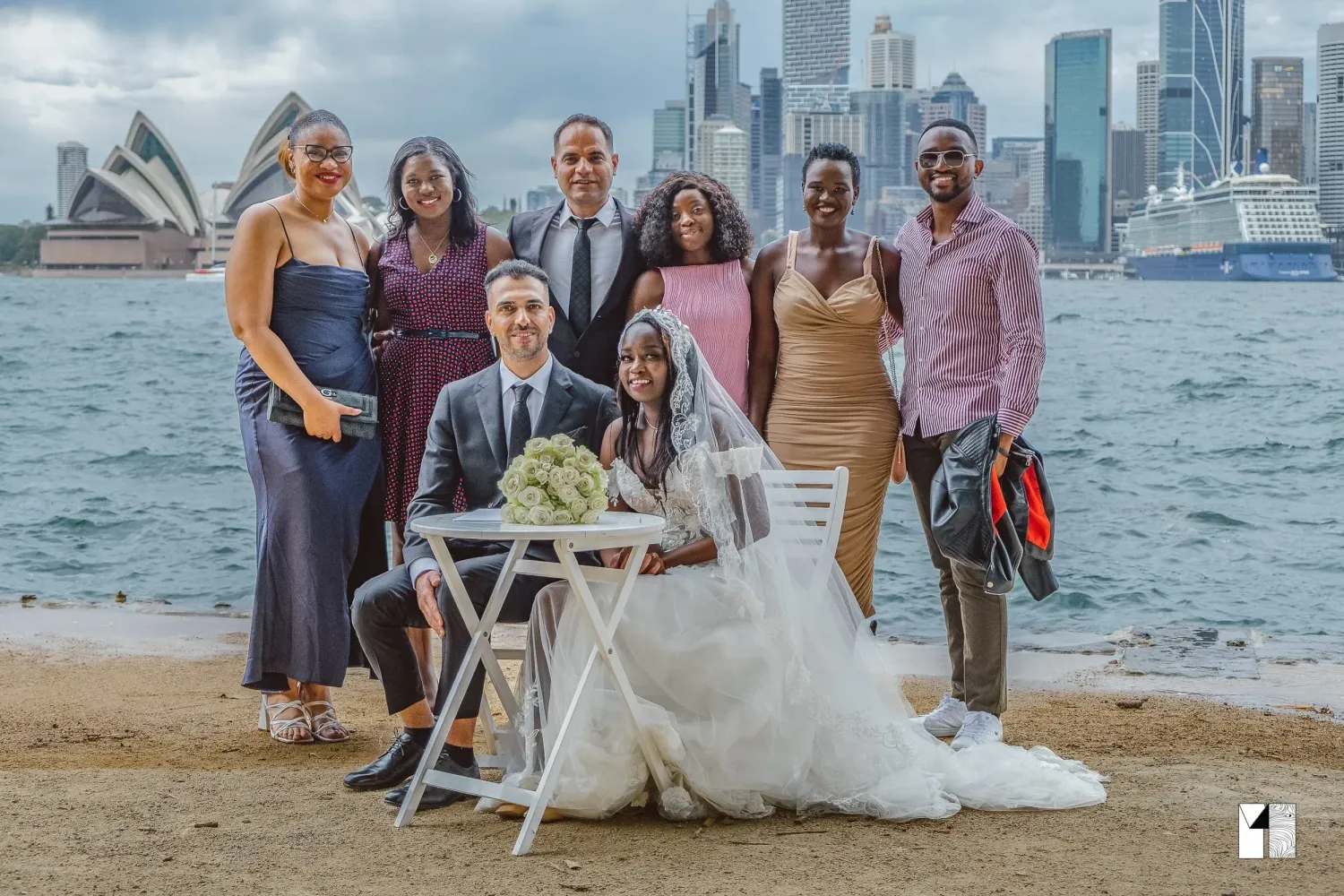 Wedding party group photo with bride and groom at Sydney Harbour with Opera House view.