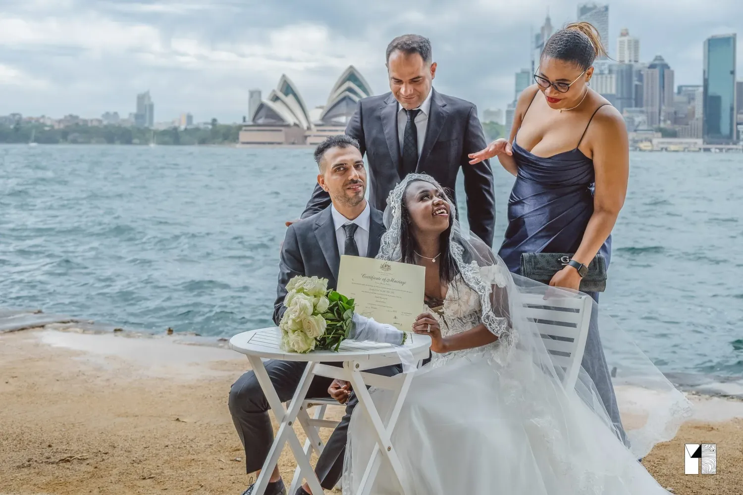 Wedding couple signing marriage certificate outdoors with Sydney Opera House backdrop.