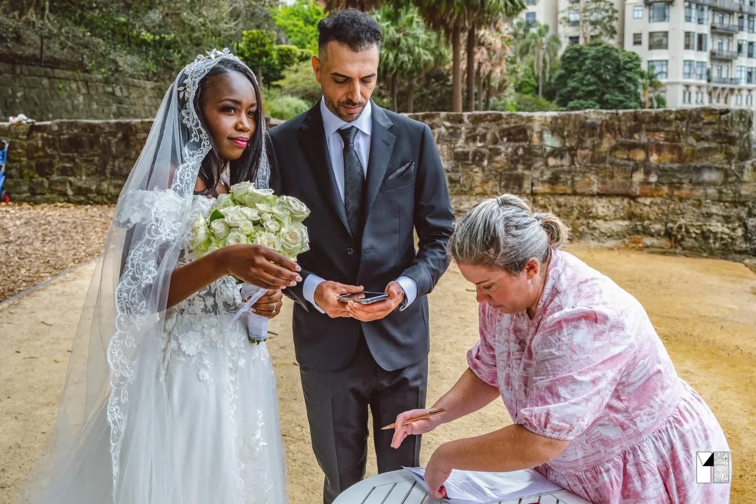 Bride and groom receive guidance from officiant during intimate outdoor wedding ceremony.