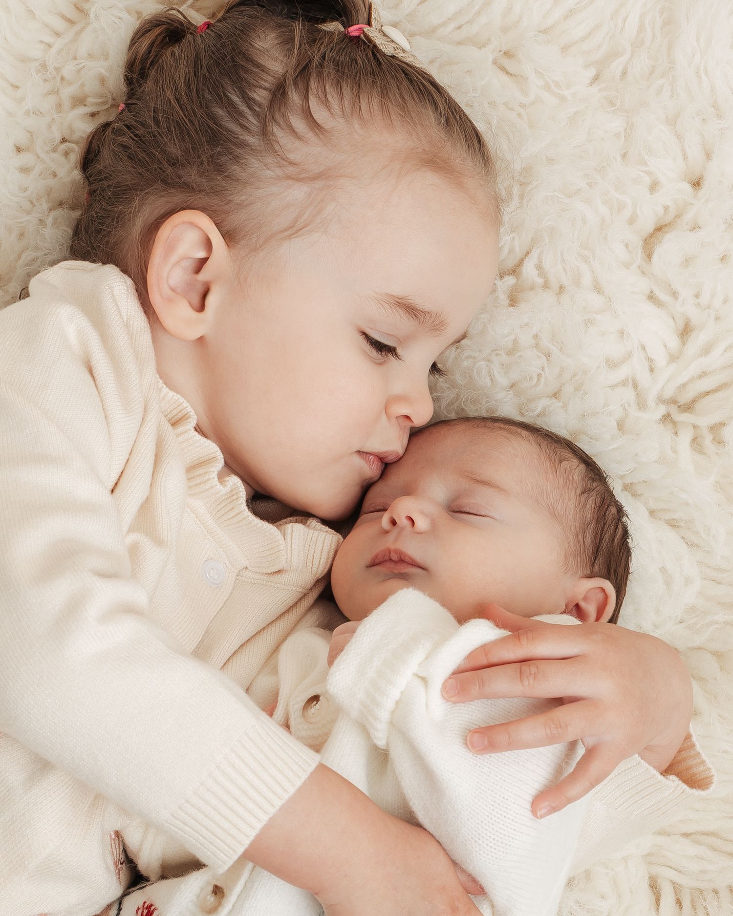 Big sister cuddling baby