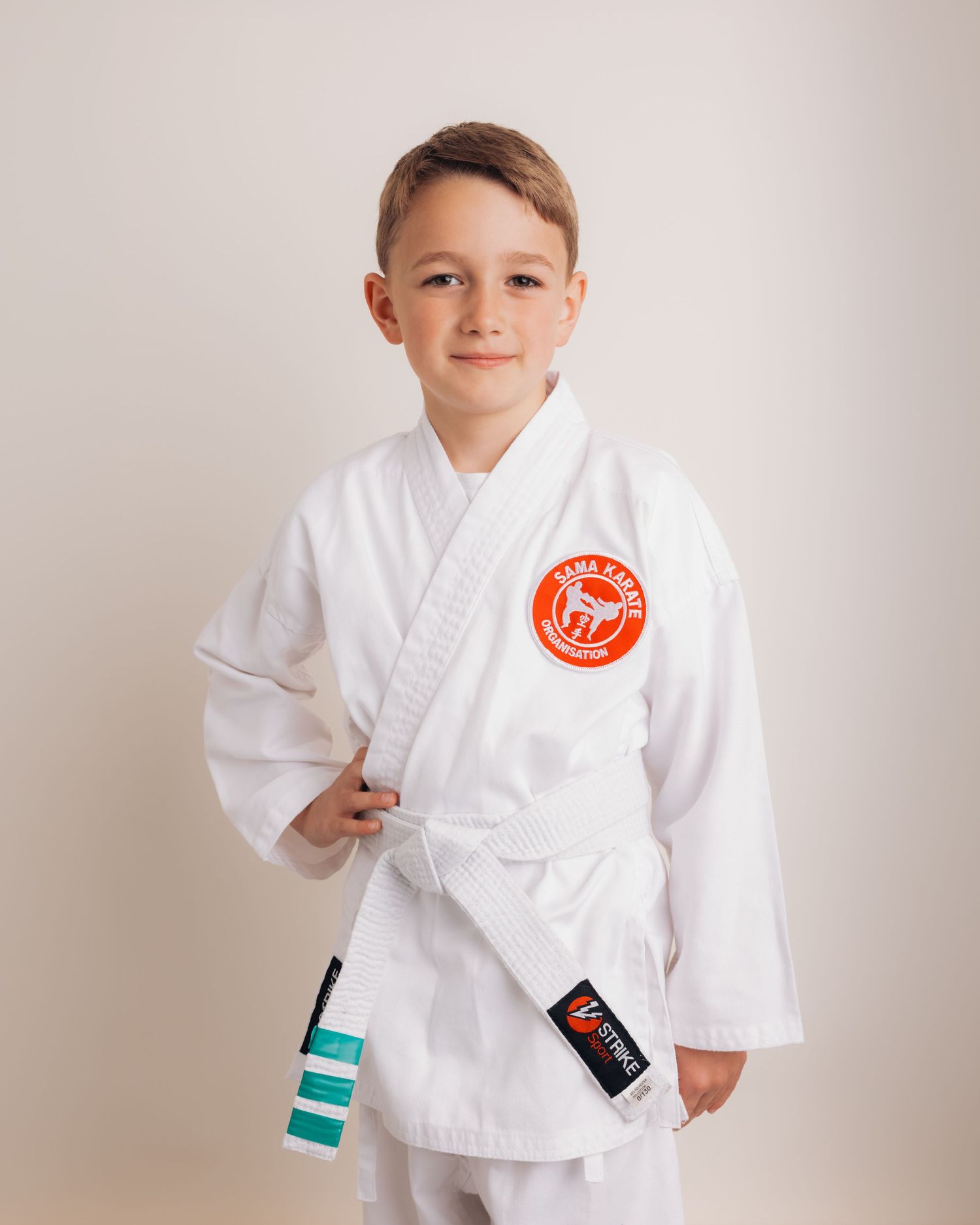 Child dressed in karate uniform, showing his favourite hobby