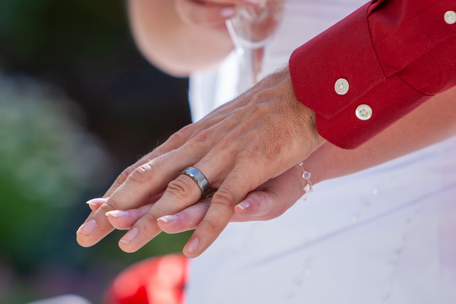 Close-up of a couples hands showing a wedding band after the ring exchange ceremony.