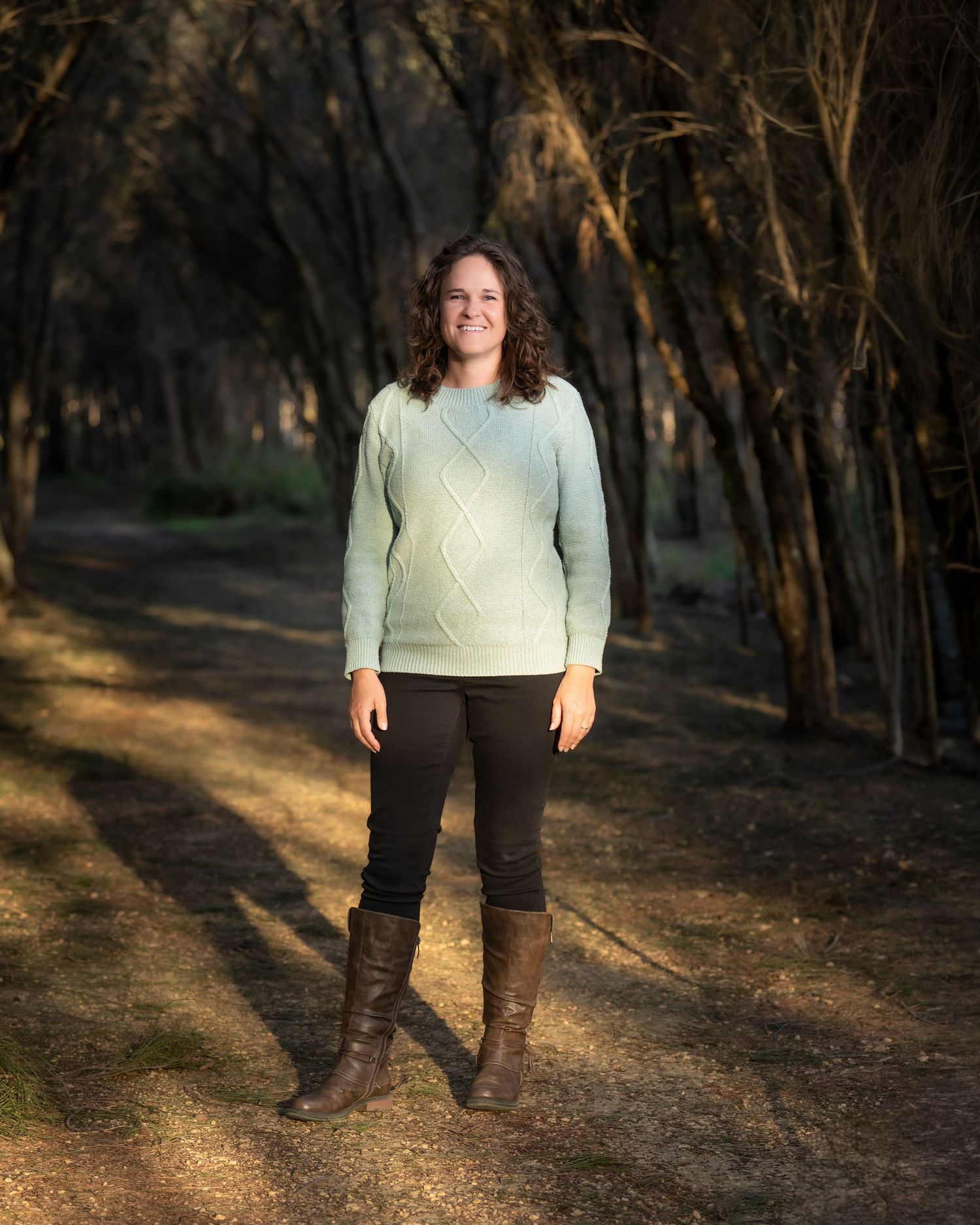 Outdoor portrait of a woman captured in natural, golden‑hour light.