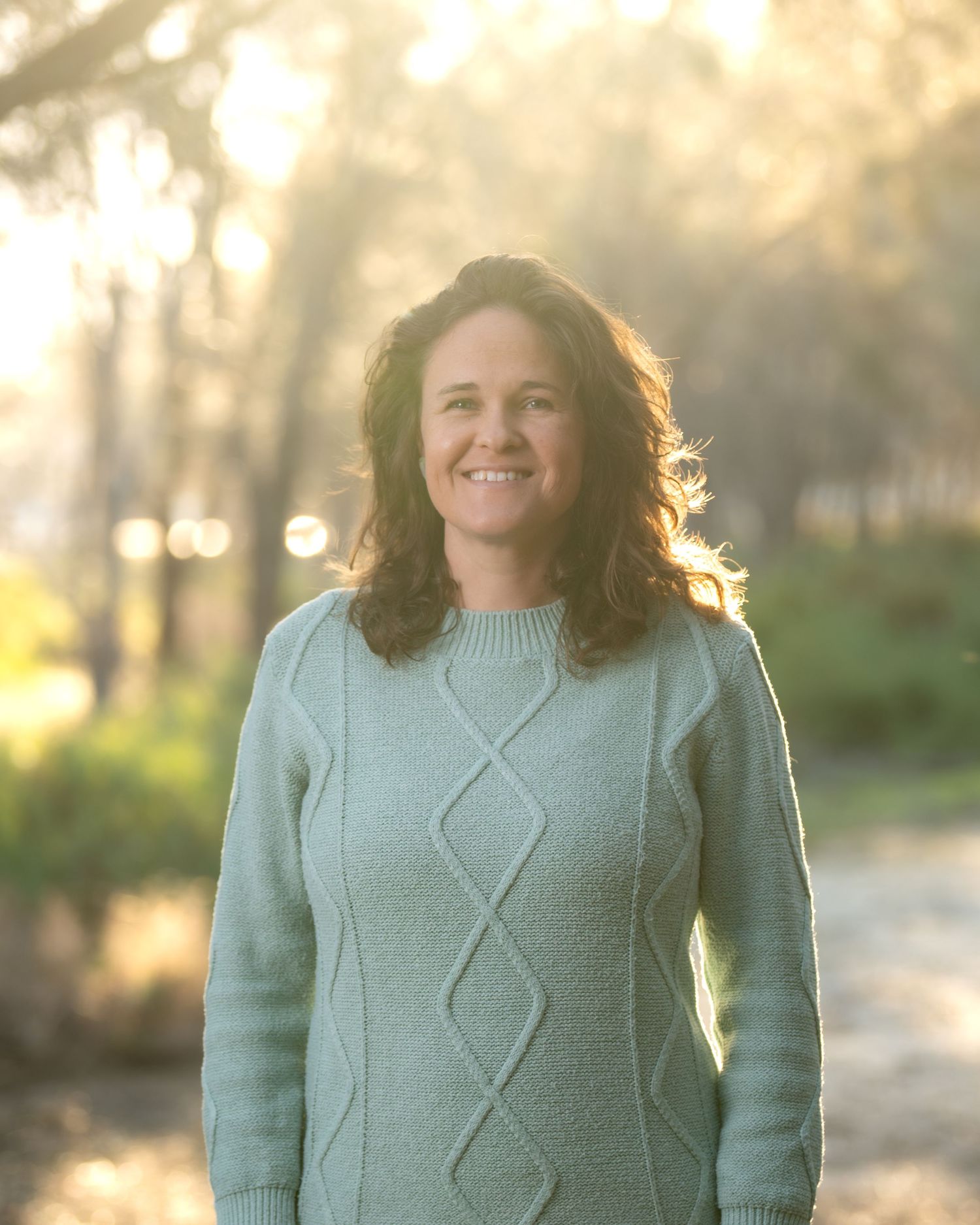 Outdoor portrait of a woman captured in natural, golden‑hour light.