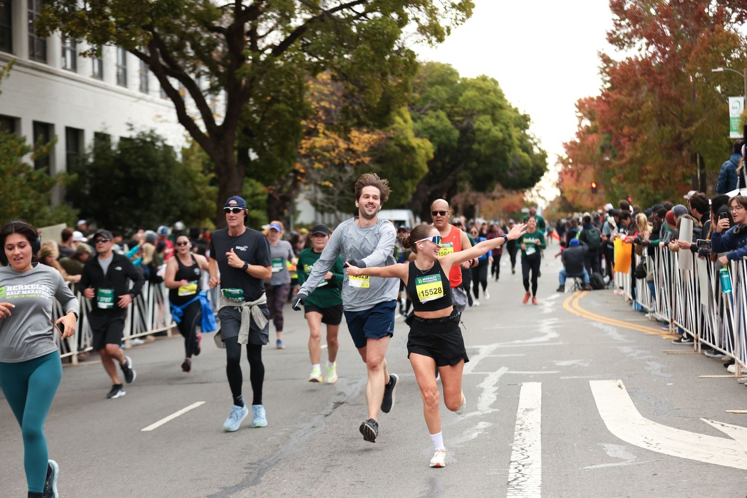 Runners race down a tree-lined street during the Berkeley Half Marathon event.