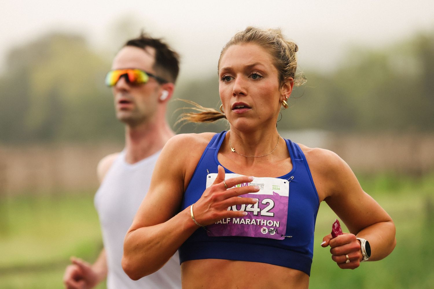 Female athlete wearing bib 142 competing in a half marathon race event.