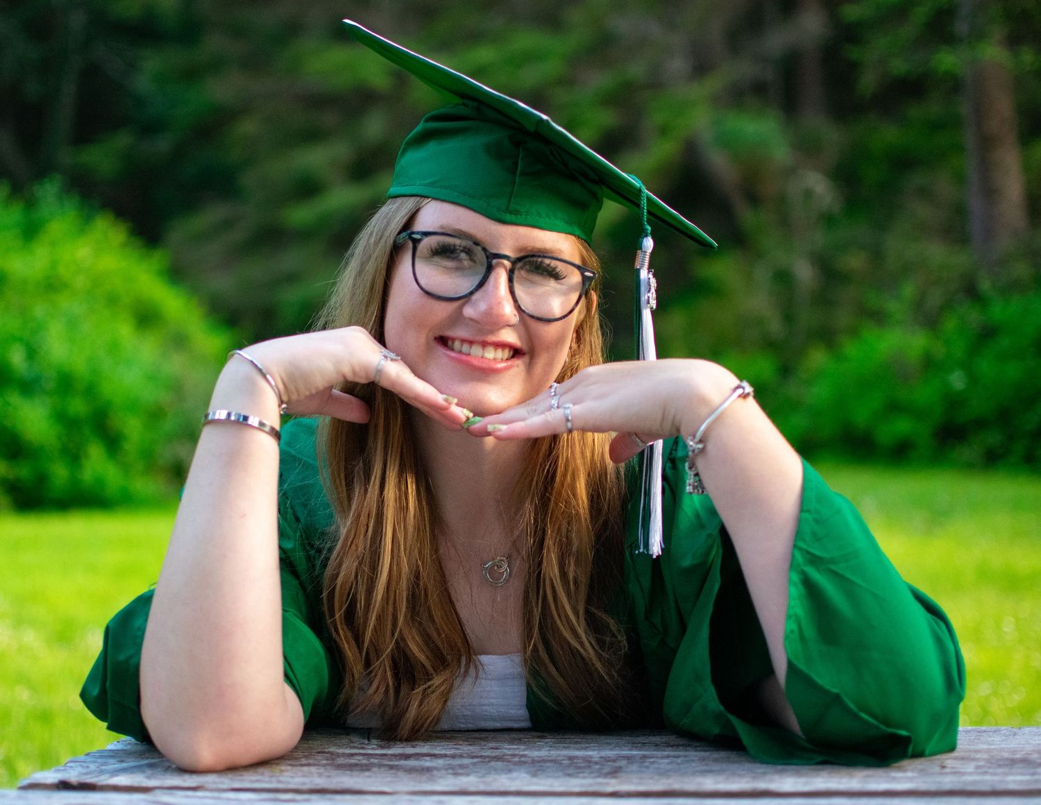 Female graduate wearing cap and gown during senior session in Newport Oregon.