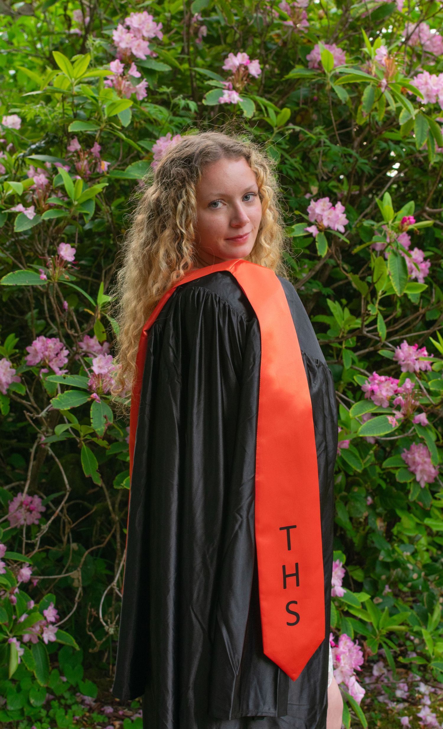 Senior girl wearing her graduation gown in Depoe Bay Oregon.