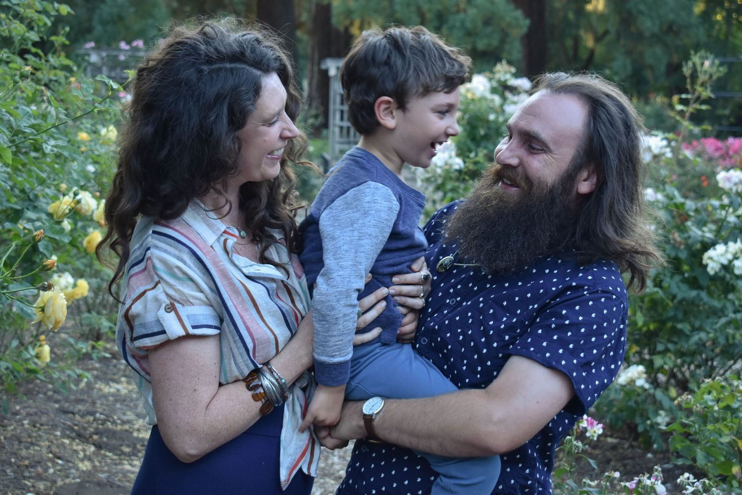 Family casually posing in front of flower garden during family photo session in Corvallis Oregon.