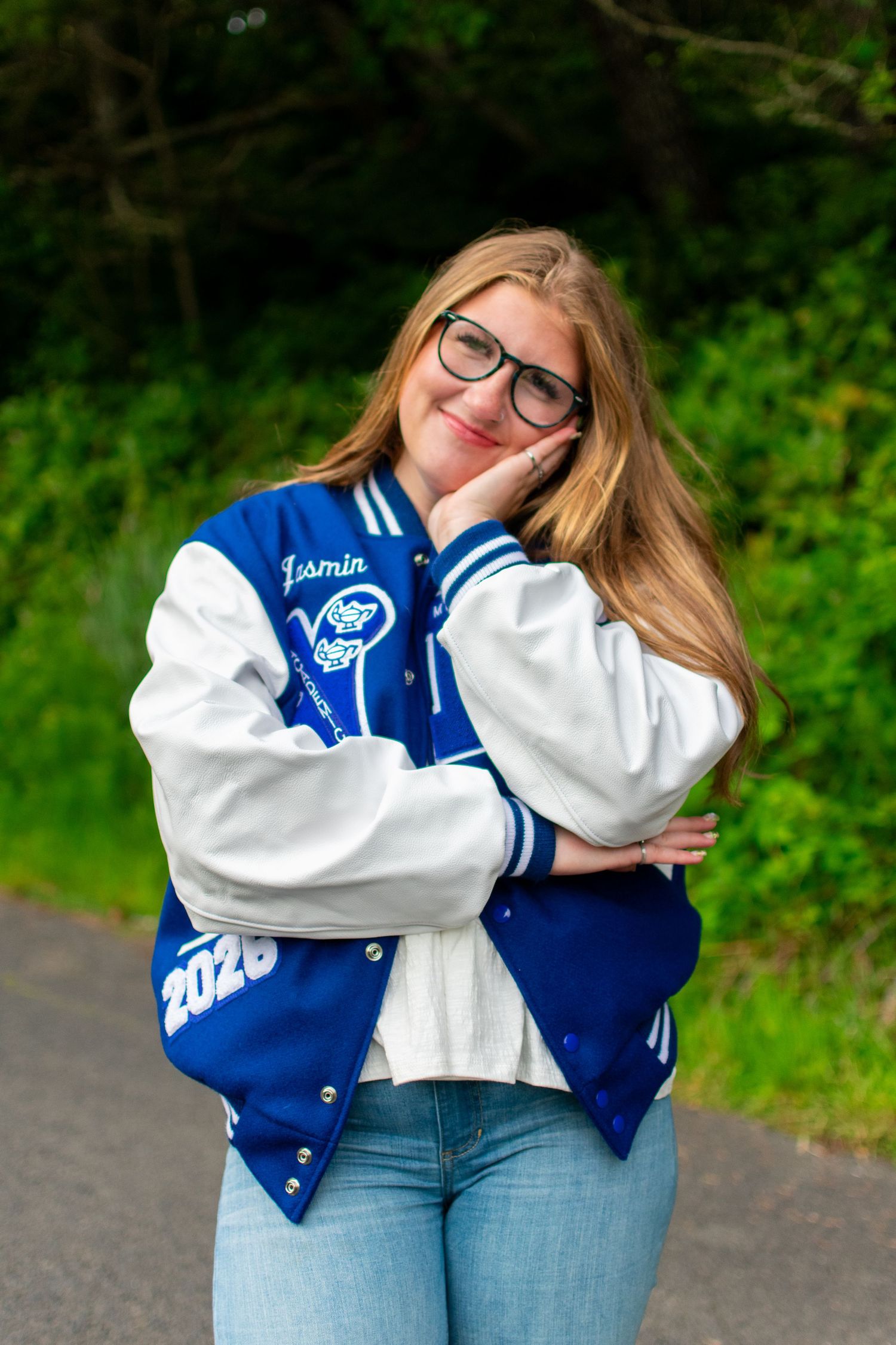 Jasmin wearing her letterman jacket during cap and gown session in Newport Oregon.