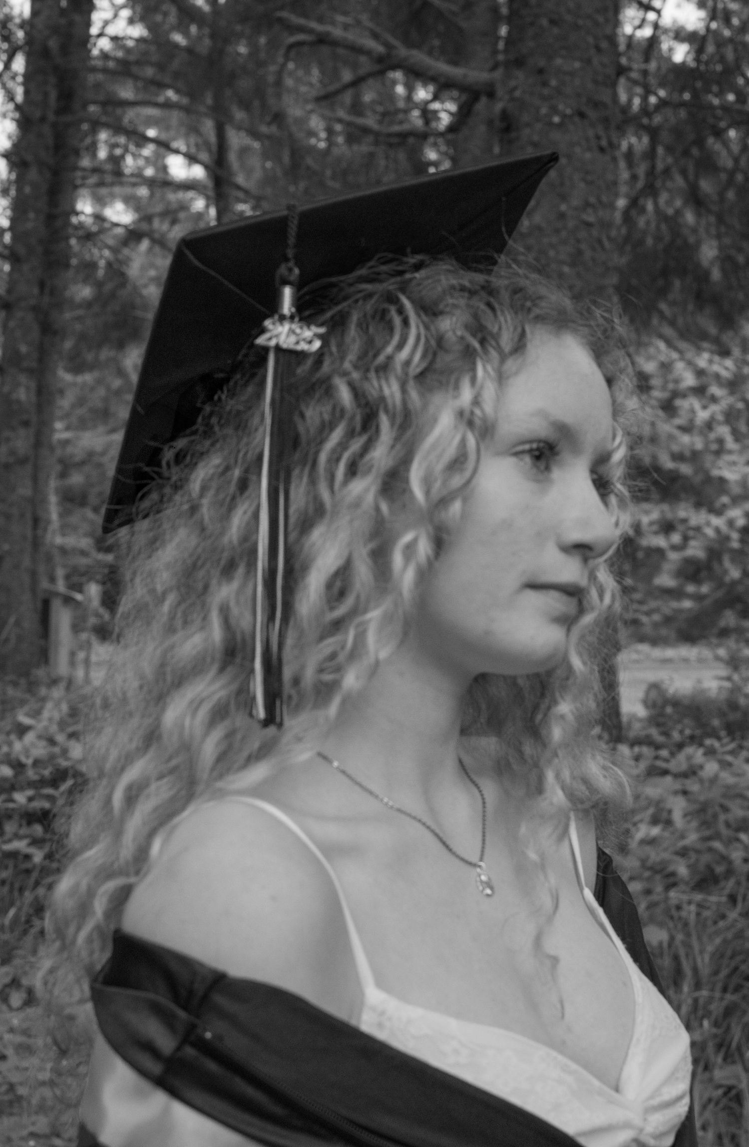 Black and white close up of female posing during cap and gown session.