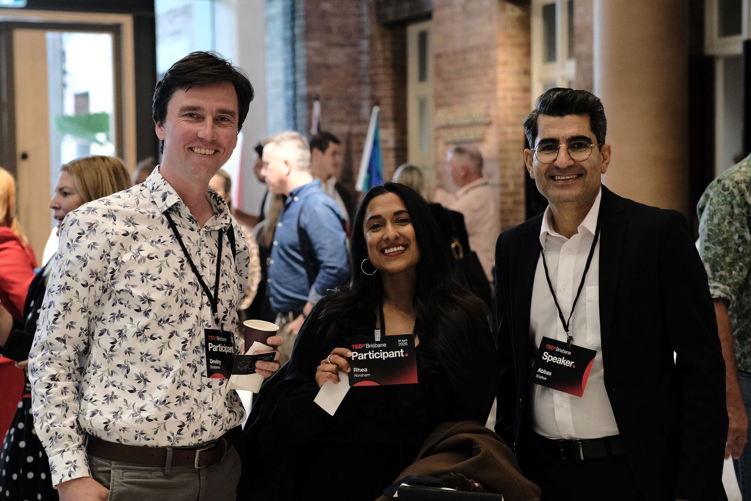 Three people smiling and posing together at the TEDxBrisbane event.