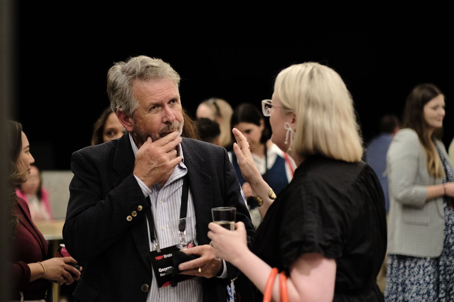 A group of people conversing at the TEDxBrisbane event.