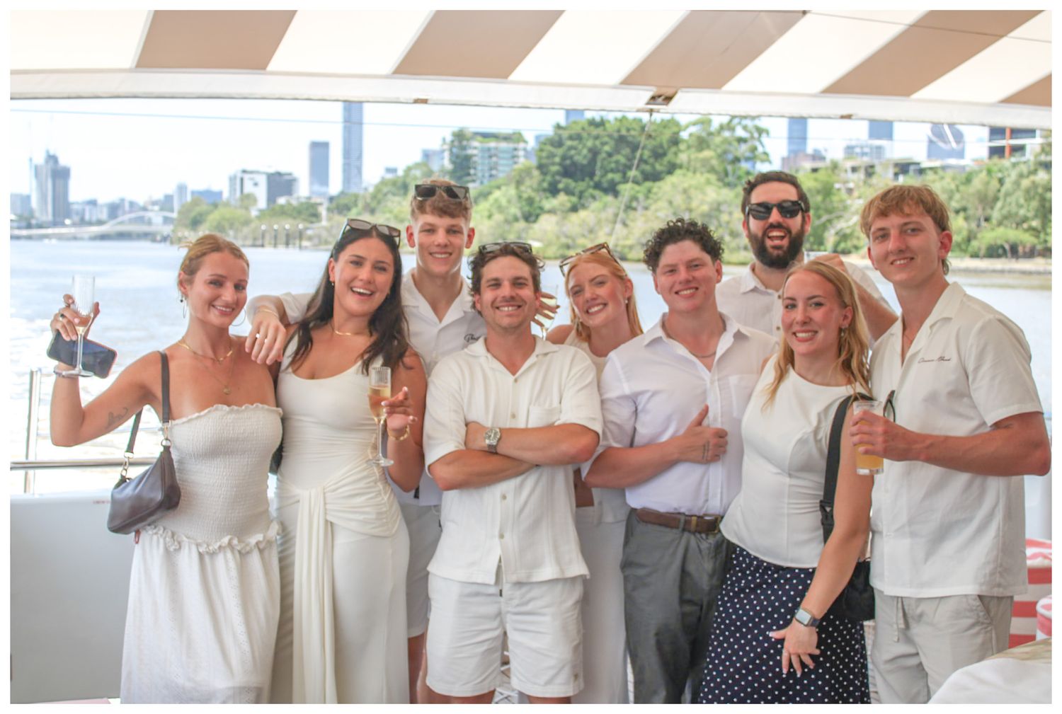 A large group of people smiling and posing together on a boat.