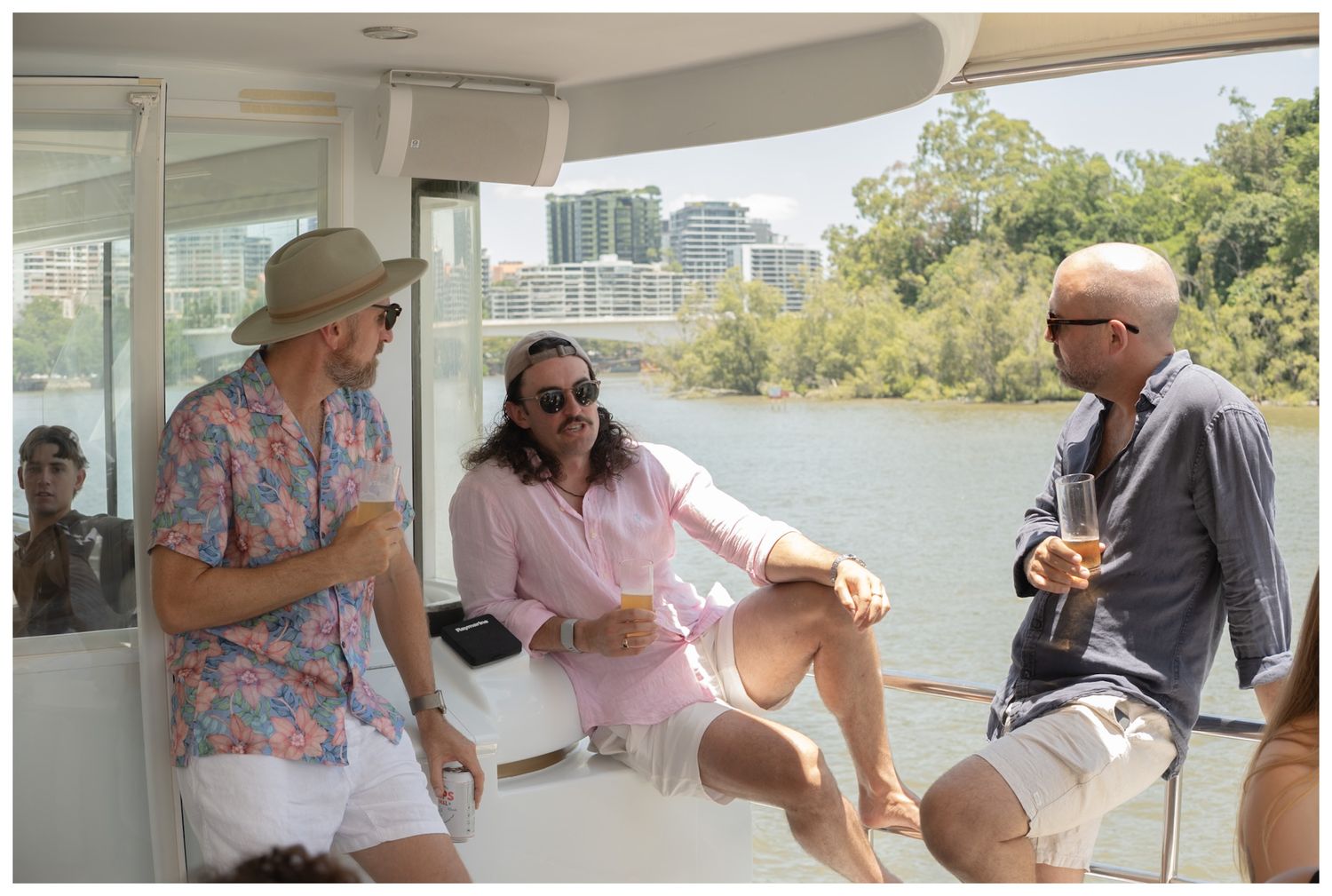 Three people chatting while sitting on a boat outdoors.