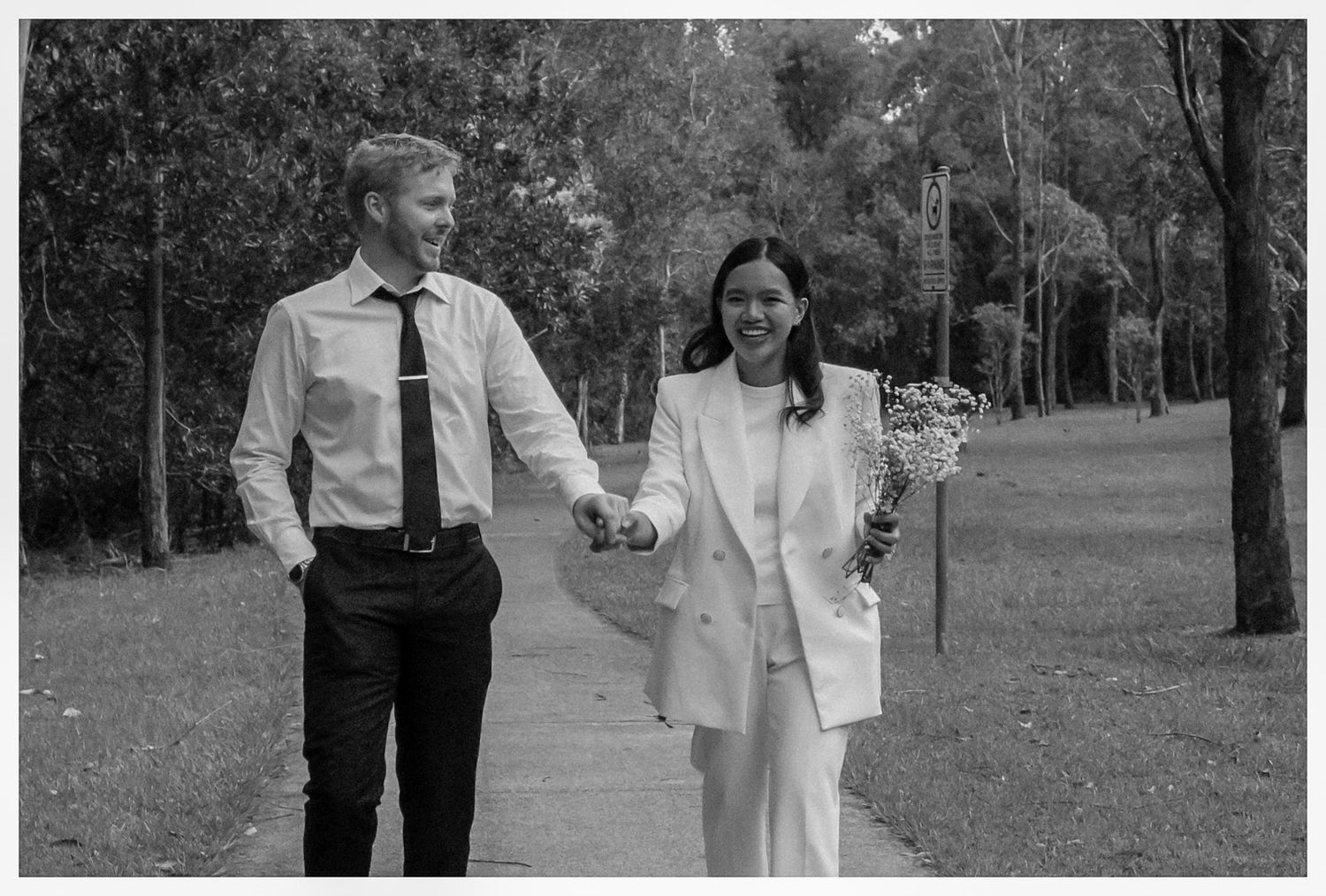 A couple dressed in white on a candid shot after their wedding ceremony.