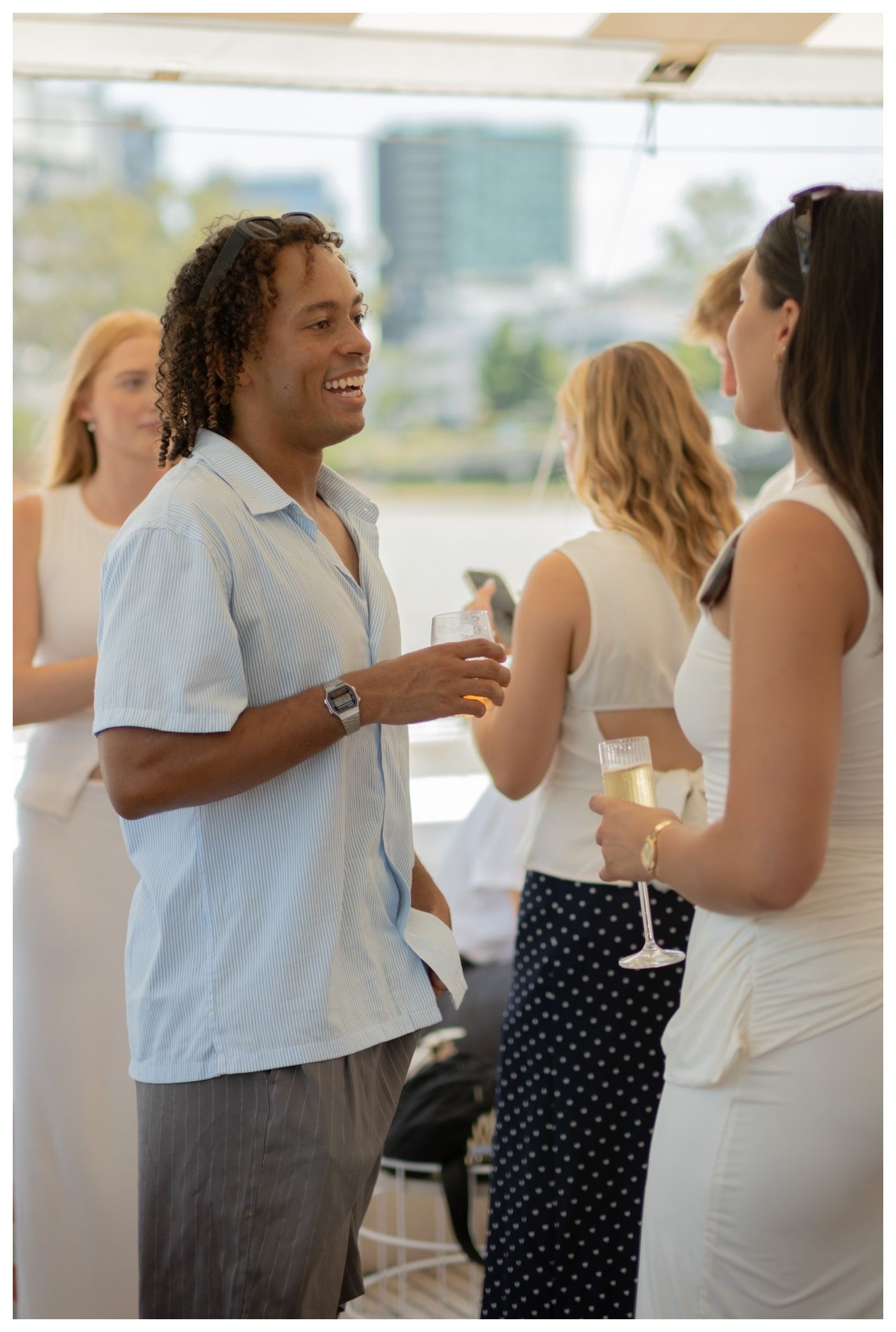 A small group of people socializing with drinks at an yacht event.