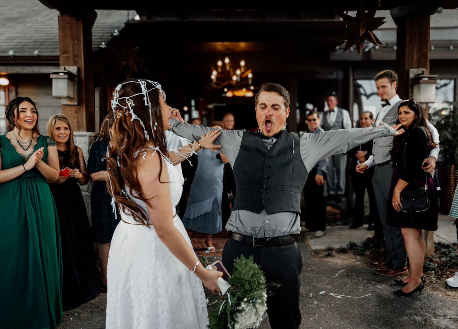 Groom reacts with joy as bride walks toward him at wedding ceremony.