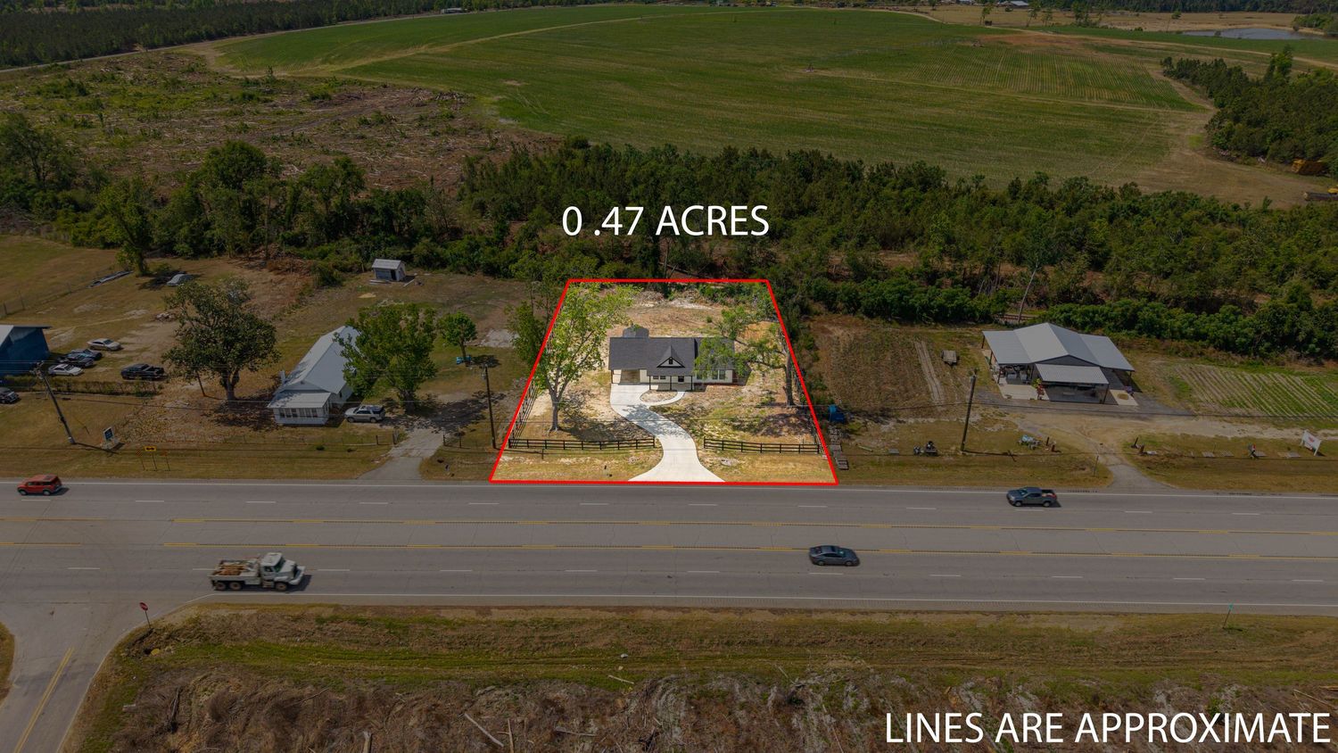 Aerial view of a 0.47-acre residential property with a house surrounded by trees, located near a rural road intersection.