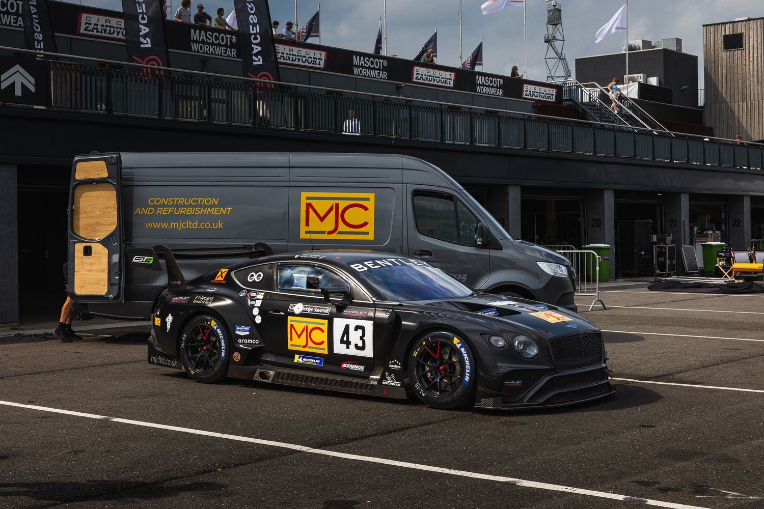Black Bentley Continental GT3 race car number 43 with MC sponsorship parked in pit lane.