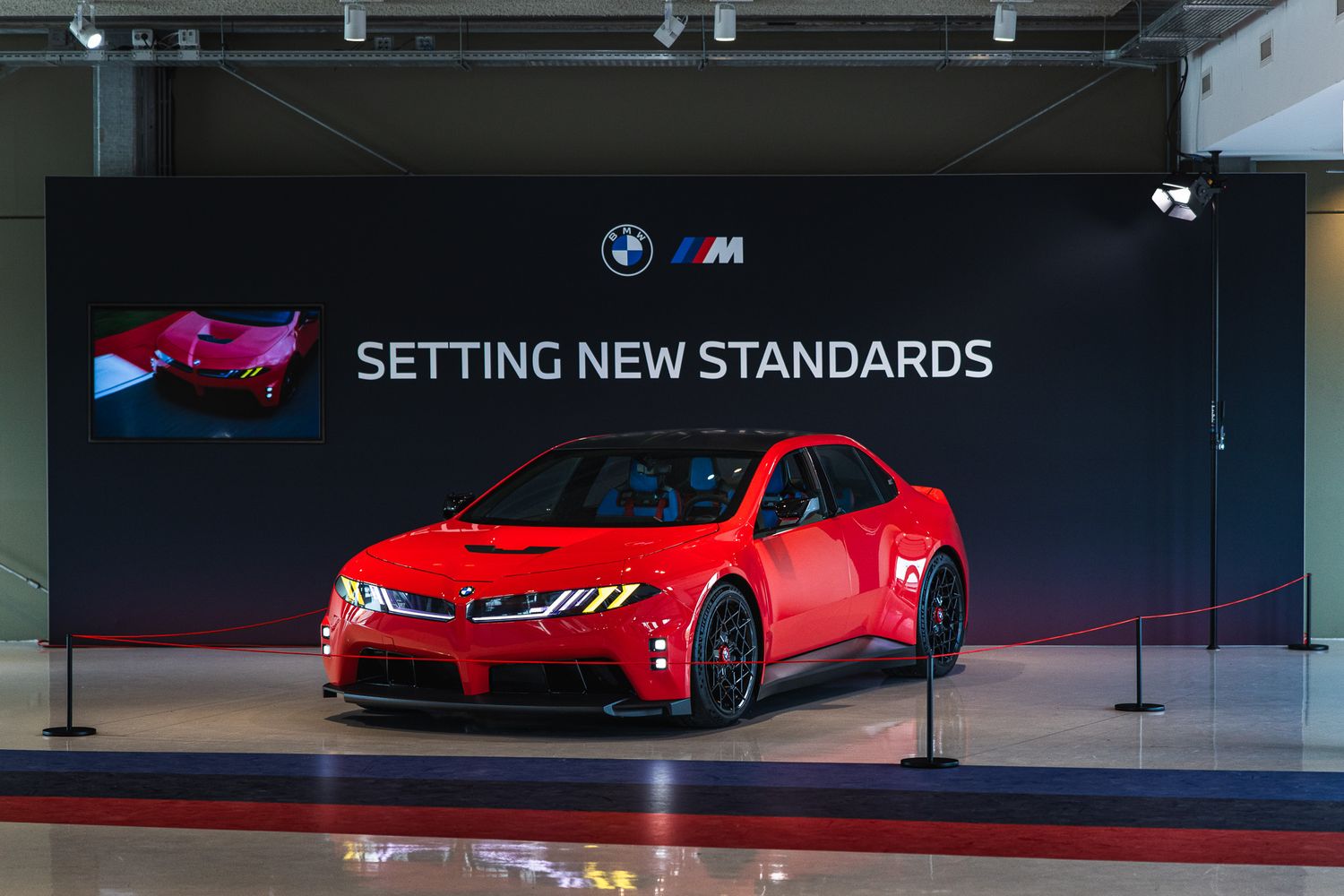 Red BMW M Performance concept car unveiled at a Setting New Standards presentation event.