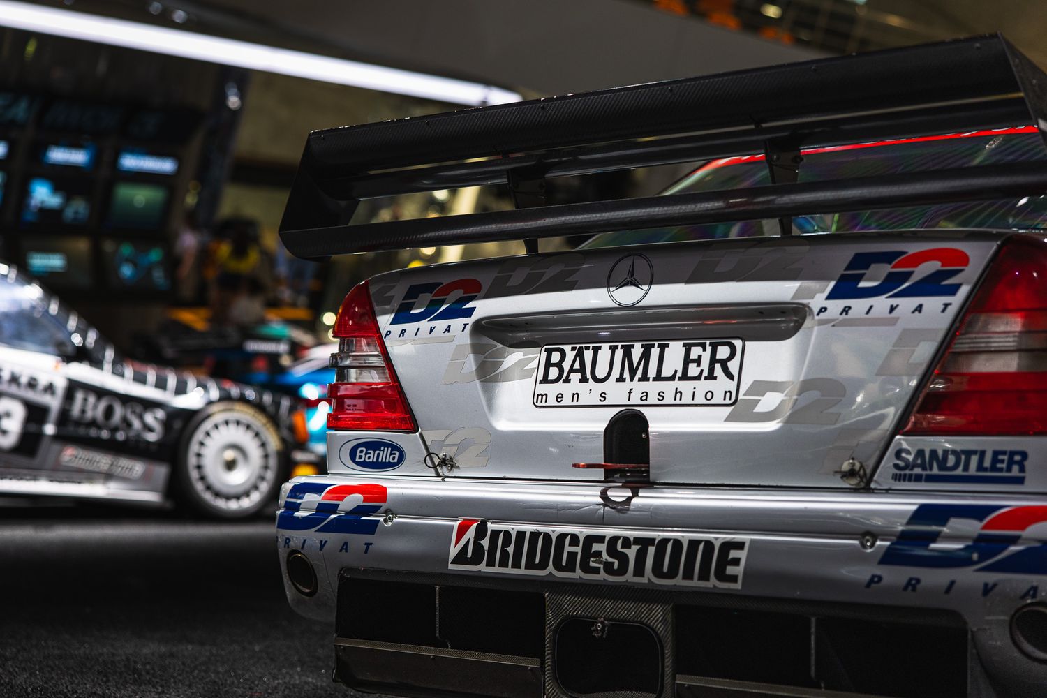 Rear view of a Mercedes-Benz DTM racing car with Baumler and Bridgestone sponsor logos on display.