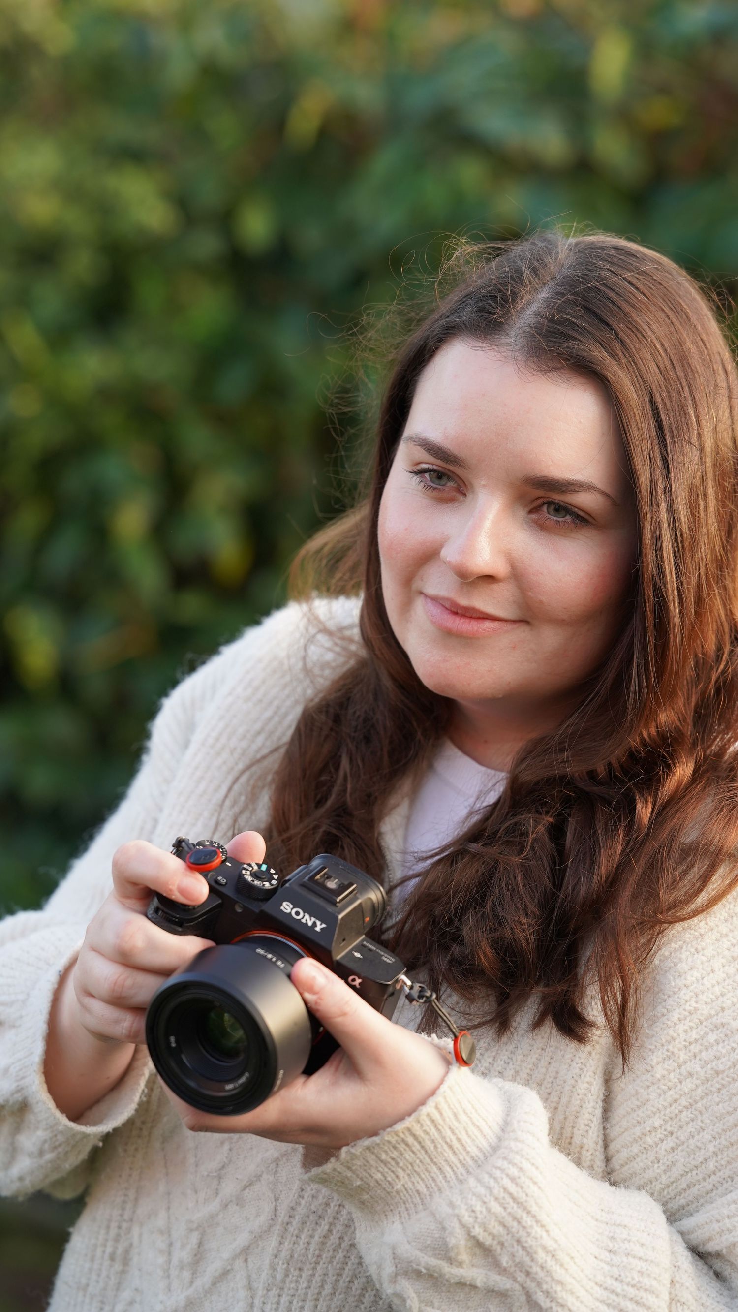 Photographer holding her camera, Suffolk.