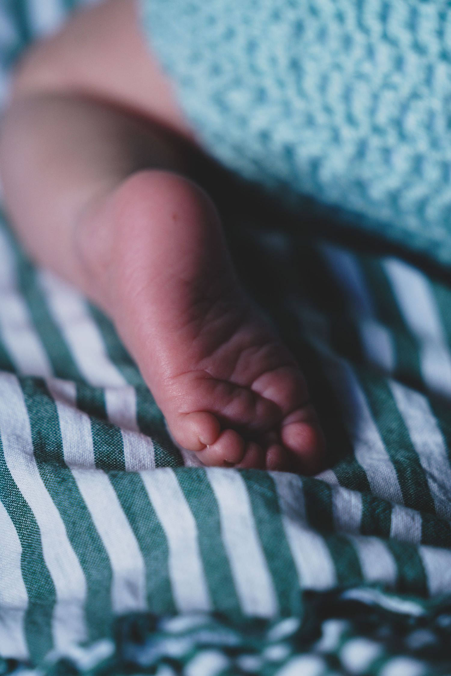 Newborn baby, at home, natural light photograph. Tiny feet.