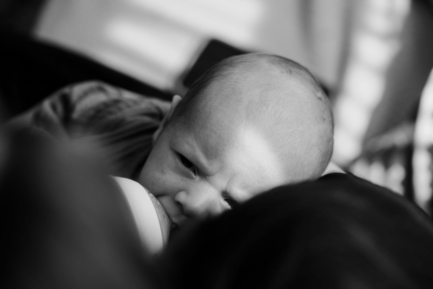 Newborn baby, at home, natural light photograph.  Baby feeding.