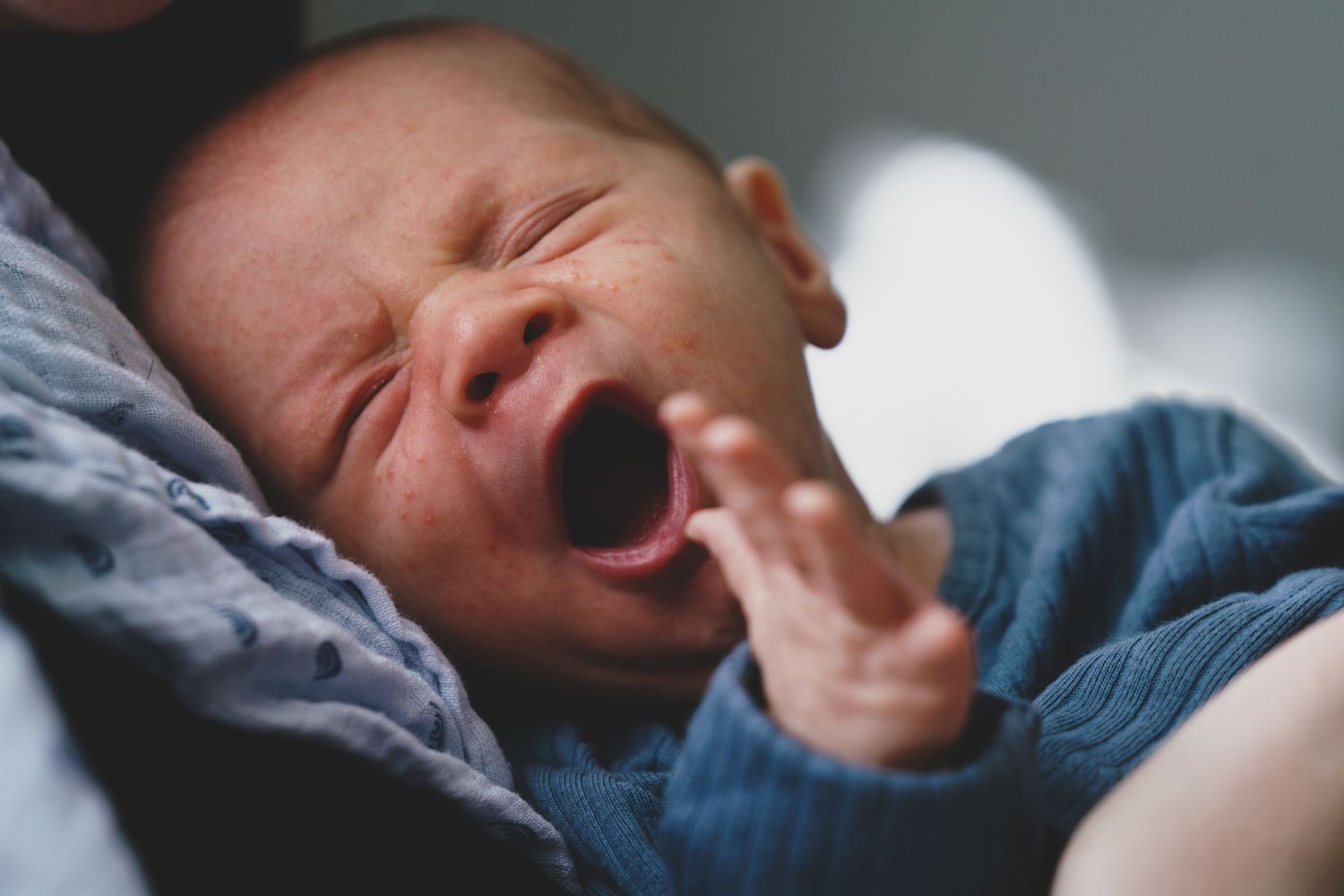 Newborn baby, at home, natural light photograph.  Yawning.