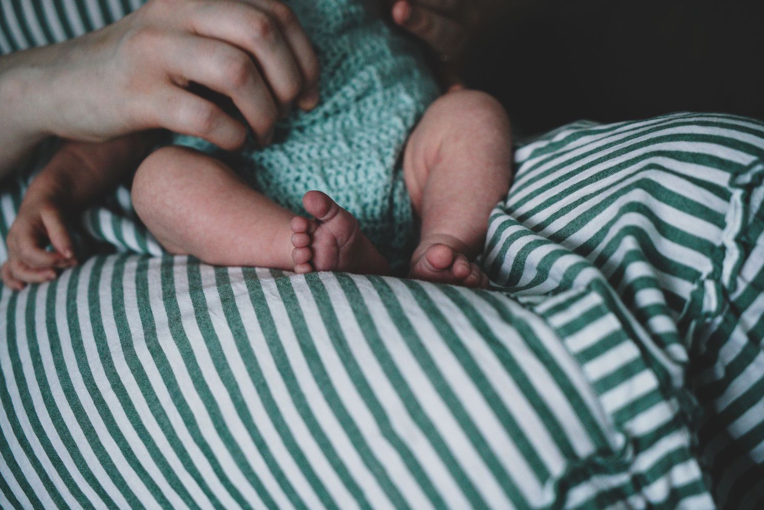 Newborn baby, at home, natural light photograph. Tiny feet.