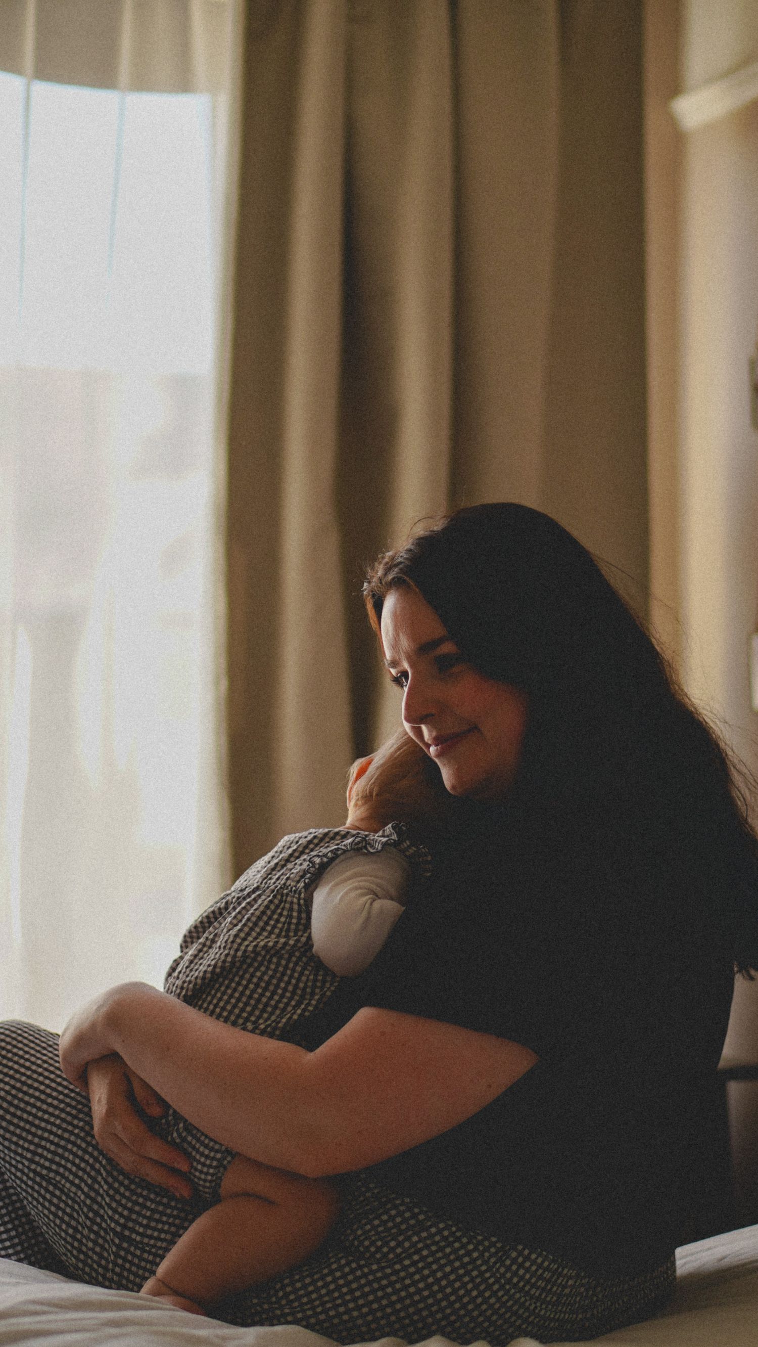 Mother and baby cuddling on the bed. natural light photography, Suffolk.